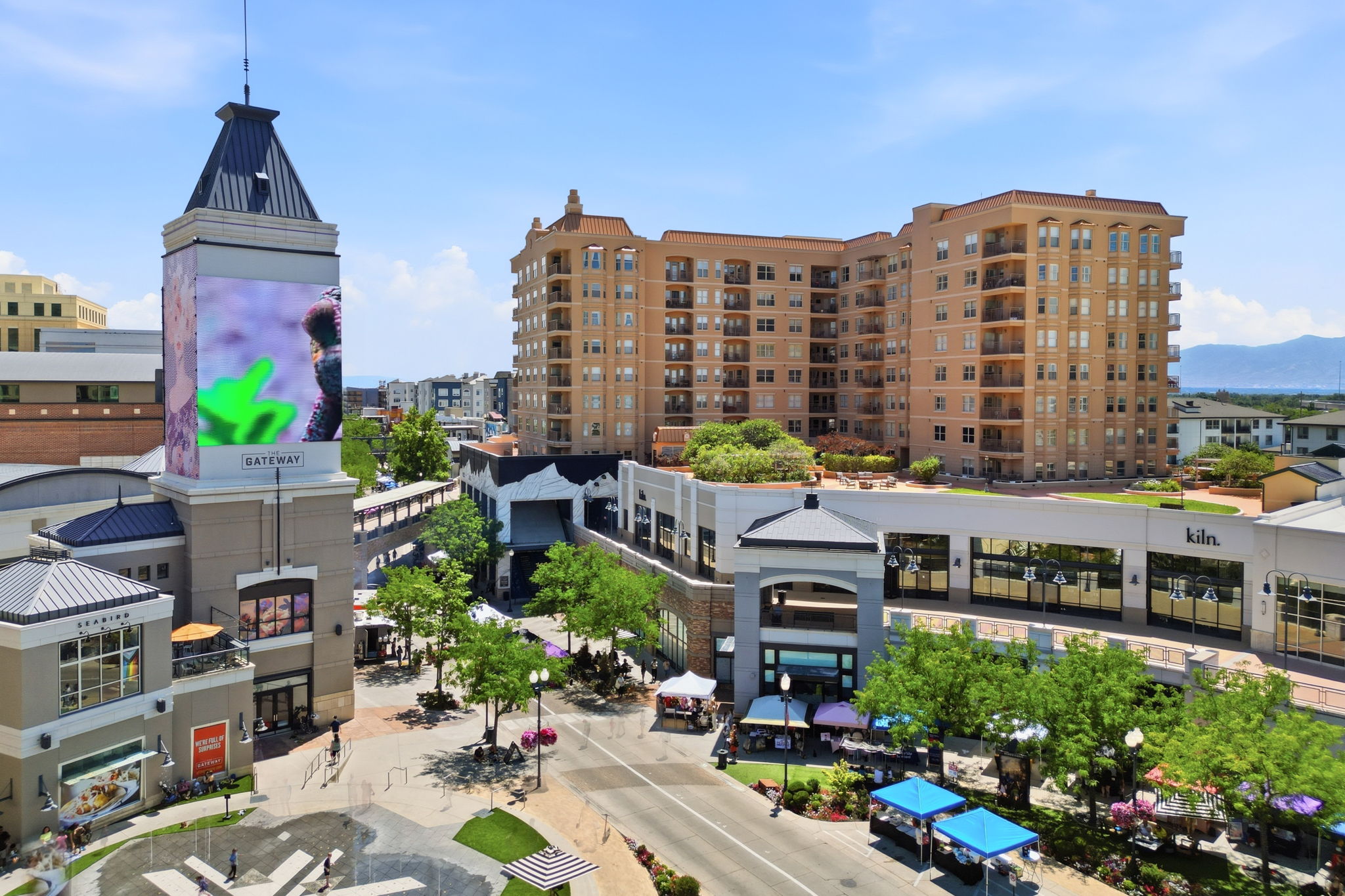 Urban multi-story building featuring multiple balconies and a large rooftop amenity space