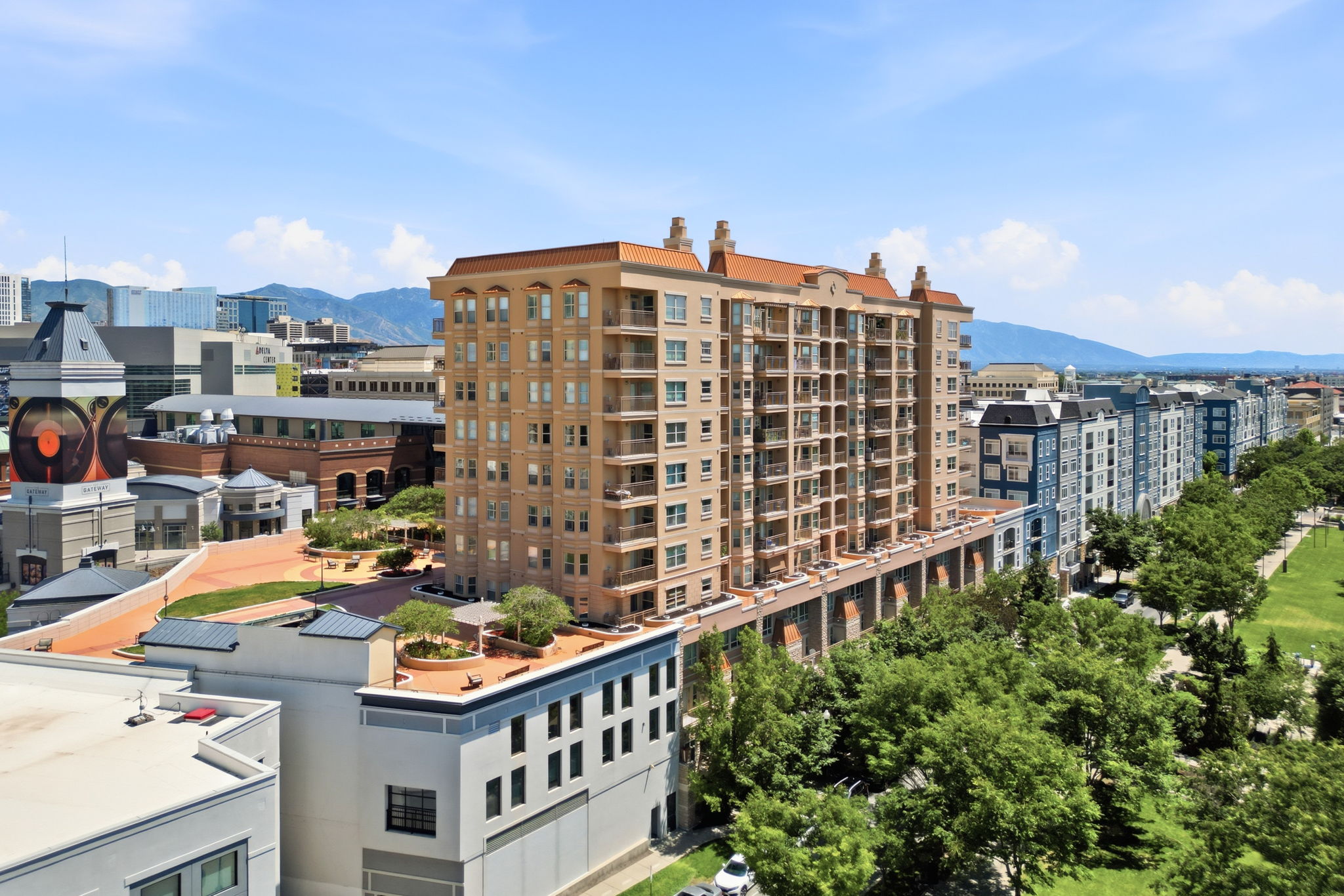 Multi-story building featuring numerous private balconies, a terracotta-style roofline, and visible architectural detailing