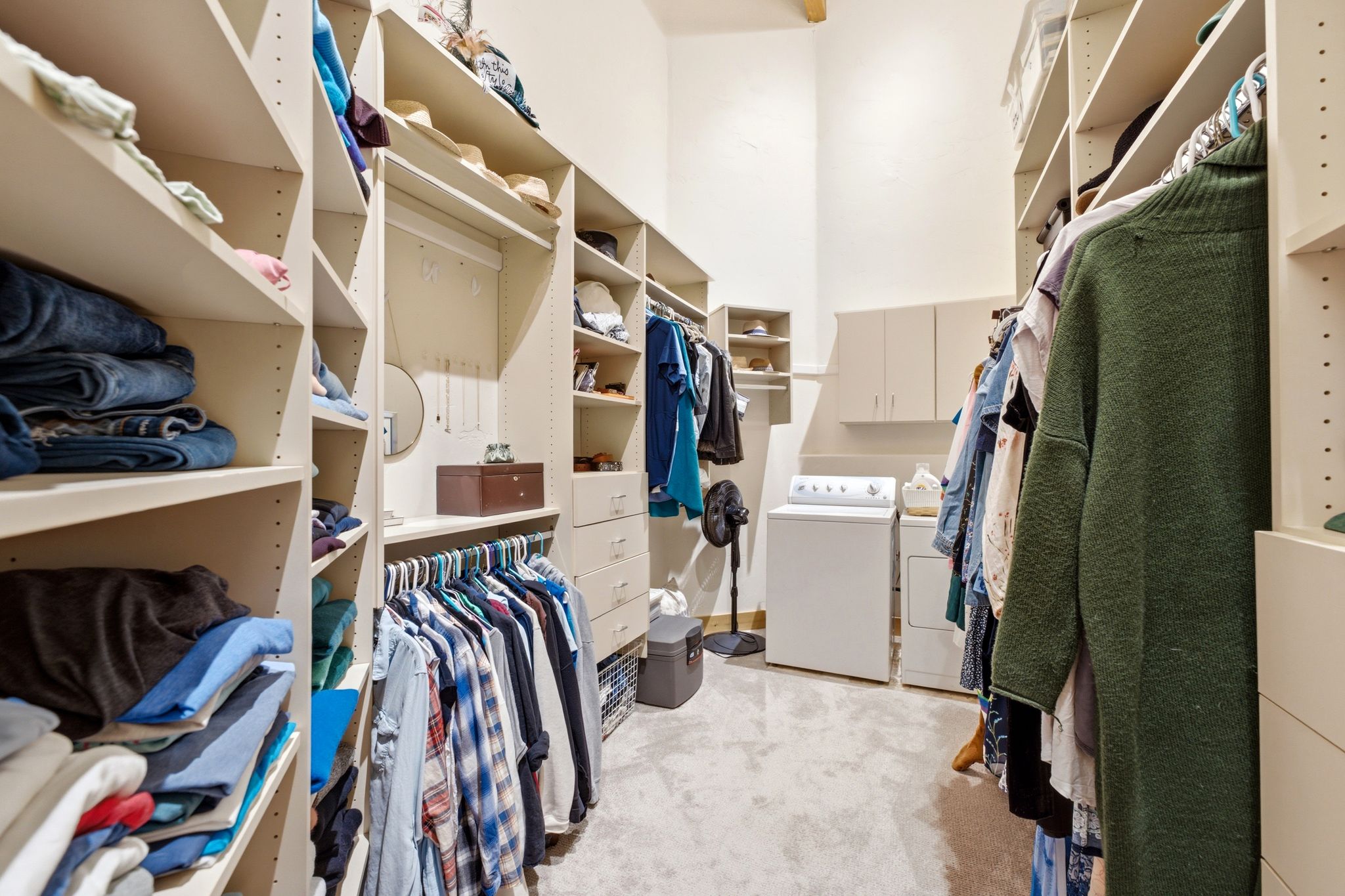 Custom closet system featuring multiple shelving units, hanging rods, and built-in drawers