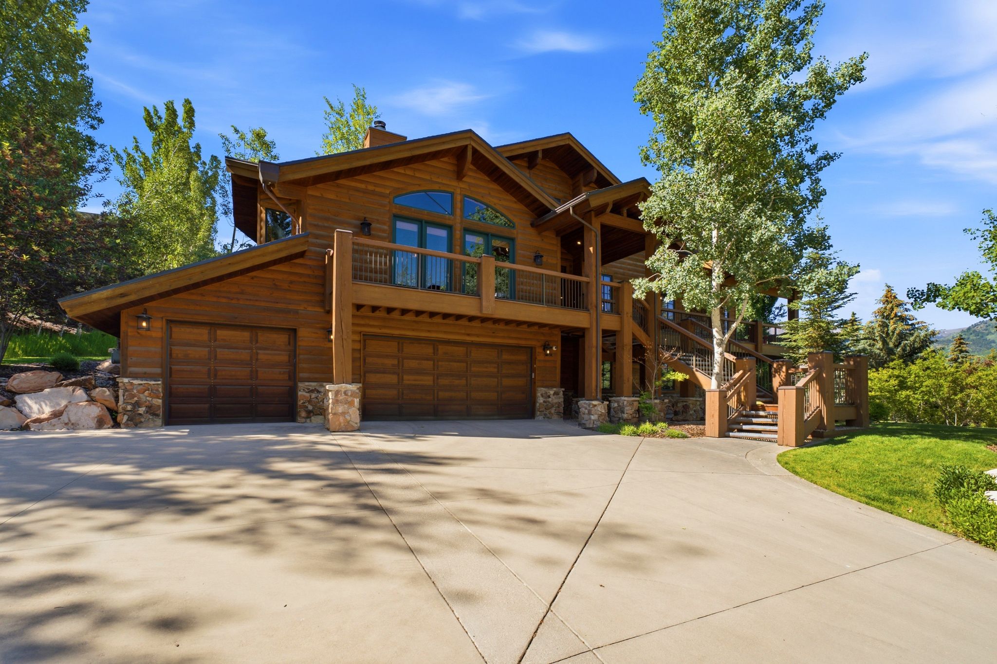 Wood-sided multi-level residence with stone accents and a multi-car garage