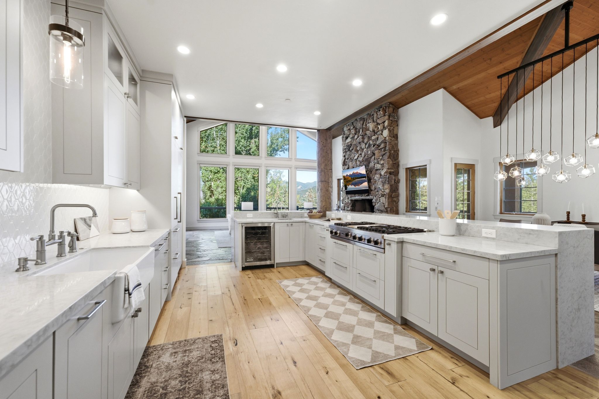 Gourmet kitchen featuring light wood-finish flooring, white shaker cabinetry, and light-toned countertops