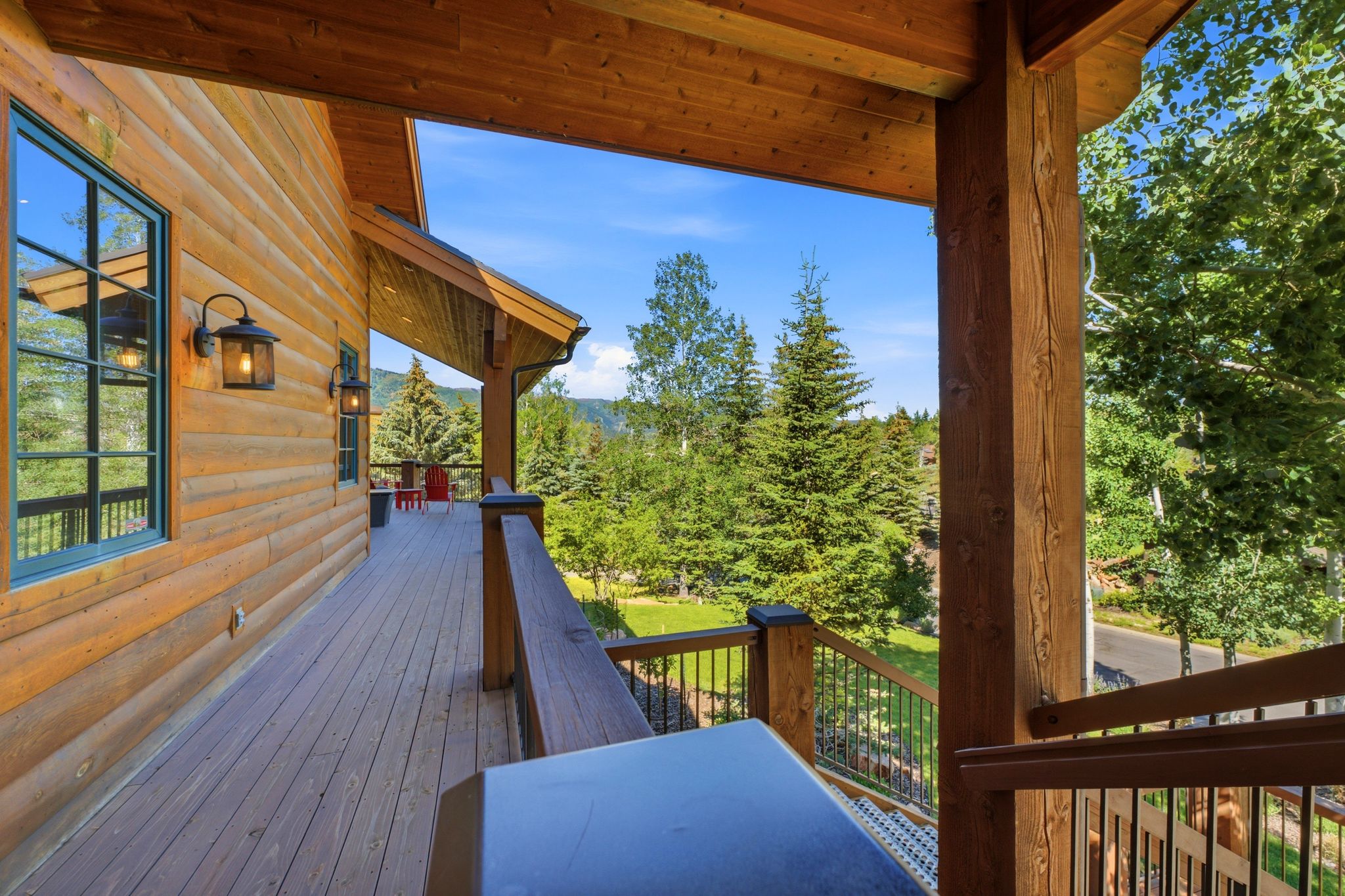 Expansive exterior deck crafted from wood planks, featuring a log-style siding