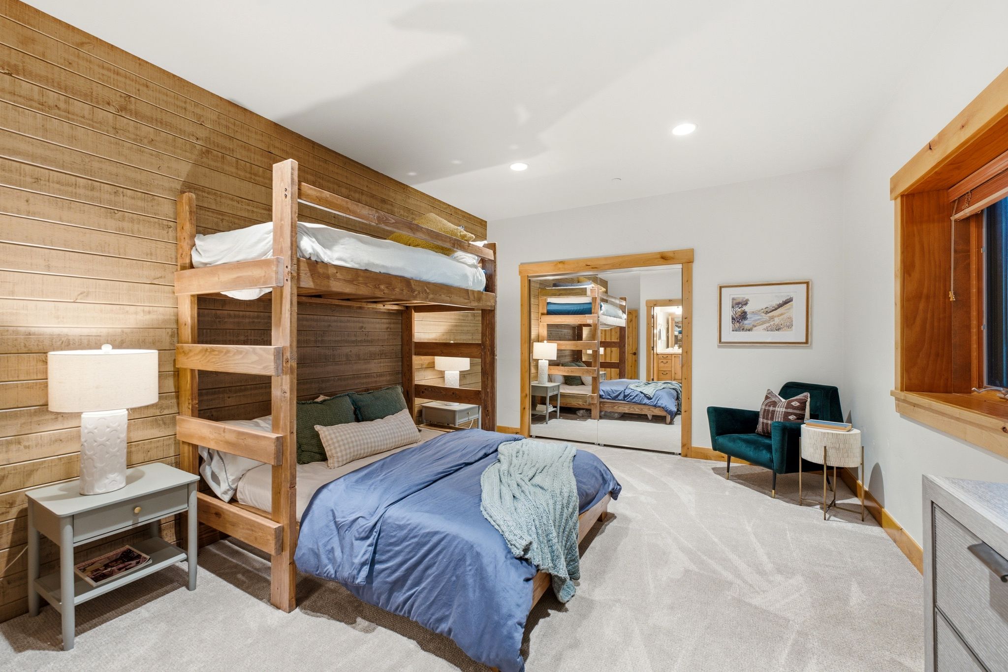 Wood-paneled accent wall featuring built-in bunk beds, recessed lighting, carpet flooring, and wood-trimmed window