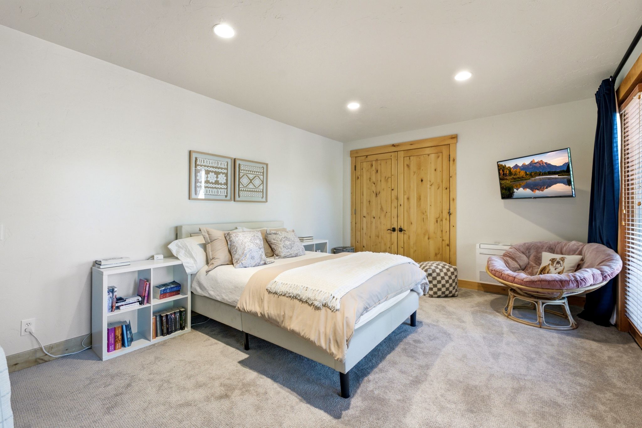 Carpeted bedroom featuring recessed lighting, a built-in closet with natural wood doors, and a glass-paneled exterior door with blinds