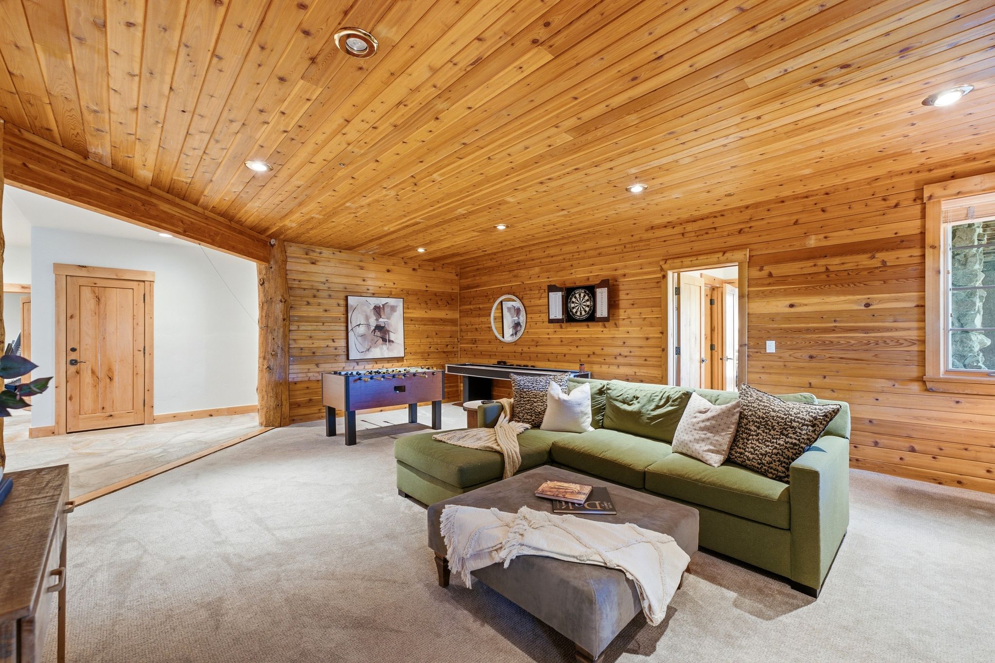 Room featuring extensive wood paneling on walls and ceiling, recessed lighting, and light-toned carpeting
