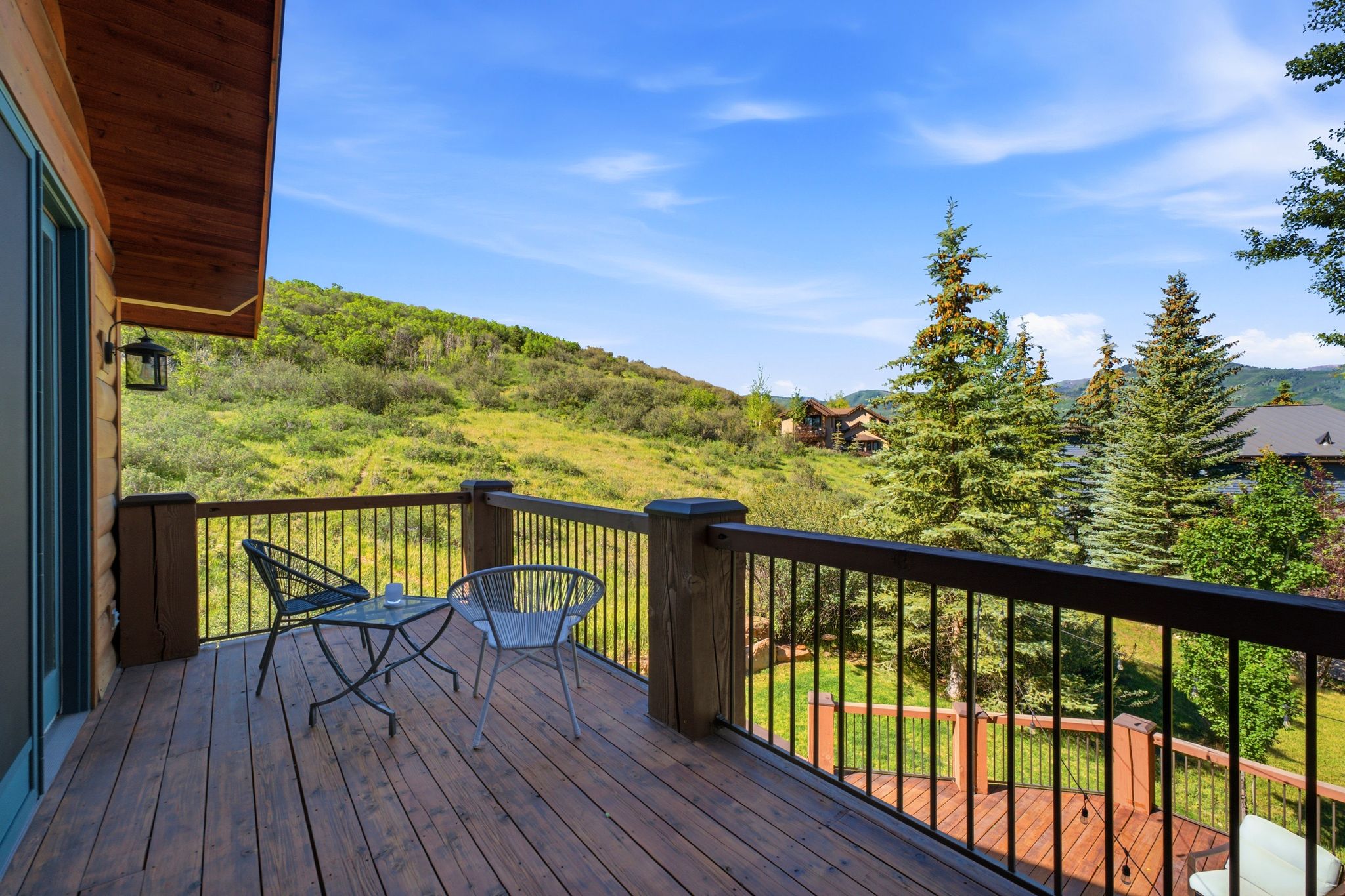 Spacious wood-finish deck with dark wood-tone railing and metal balusters