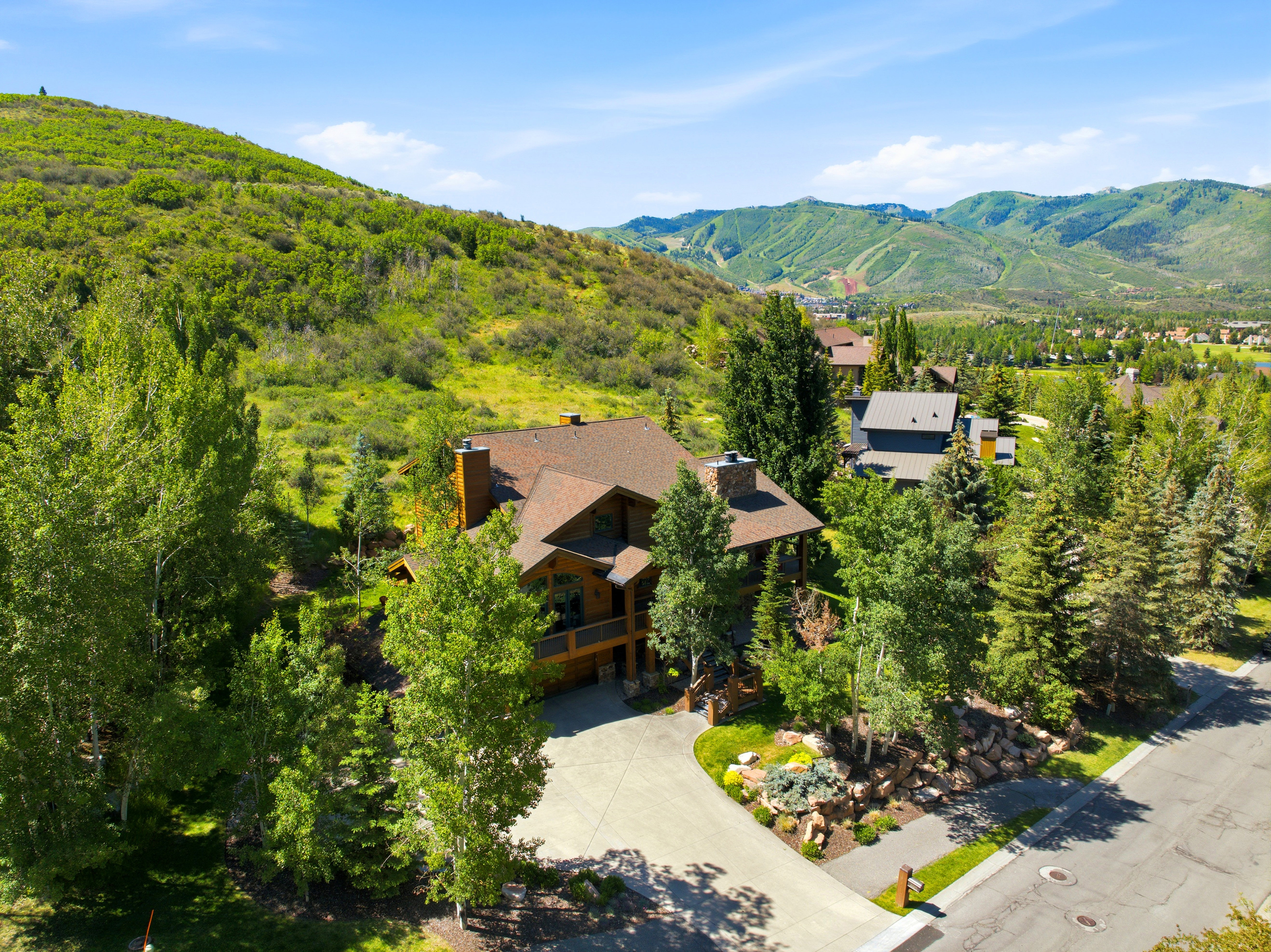 Wood-sided residence with multiple gables and a stone chimney