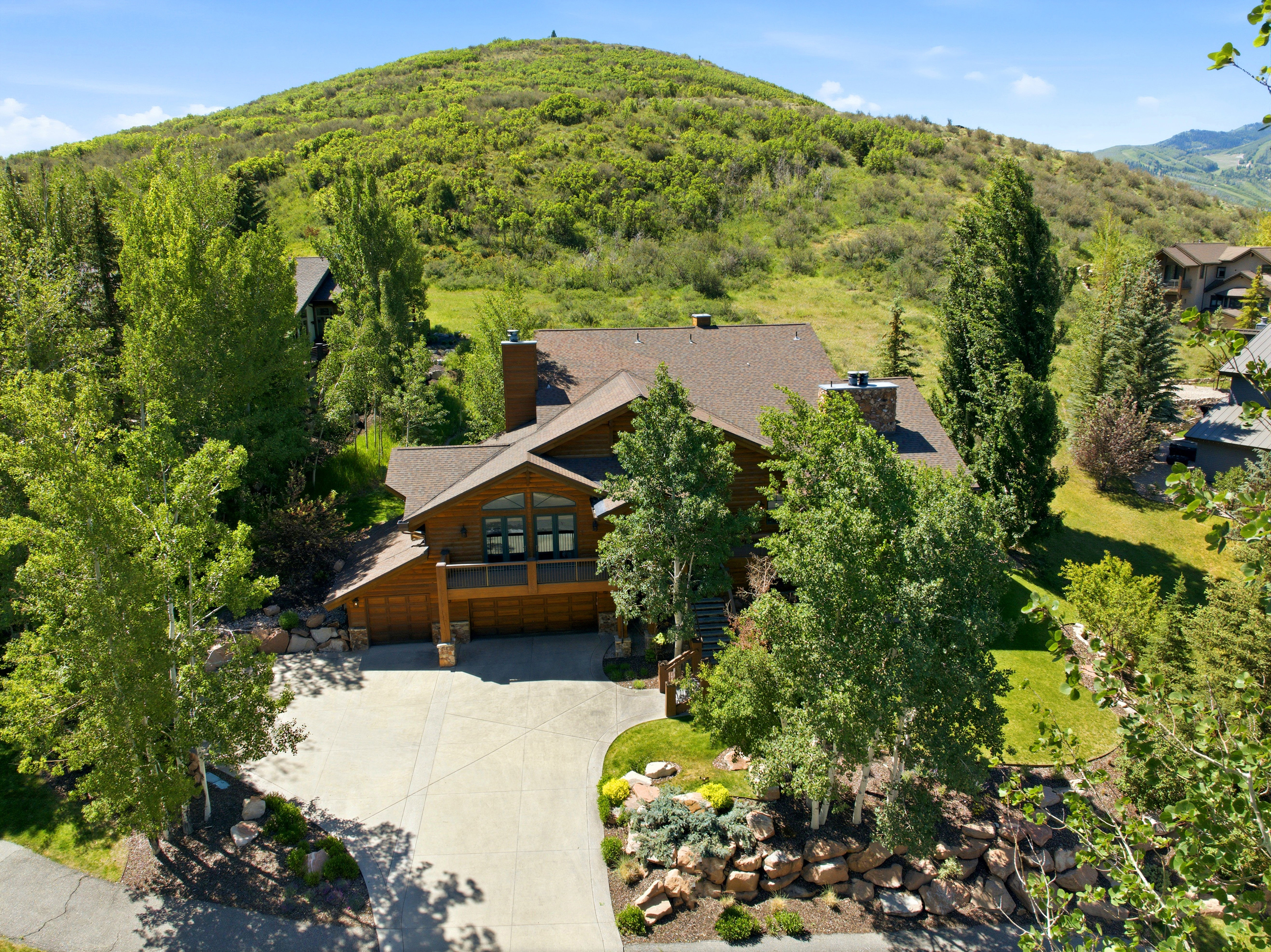 Wood-sided residence featuring a multi-gabled roofline and multiple chimneys