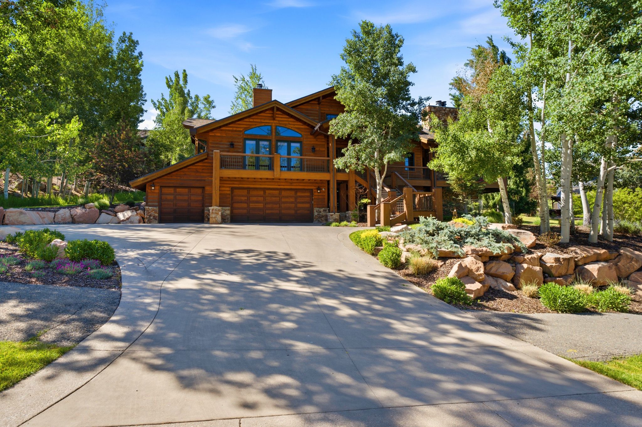 Multi-level wood-clad exterior with a prominent arched window and balcony