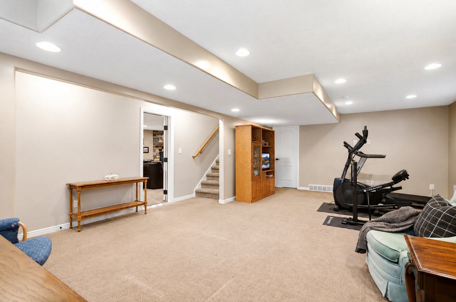 Spacious lower level featuring carpet flooring, recessed lighting, neutral wall tones, and a finished staircase with carpeted treads