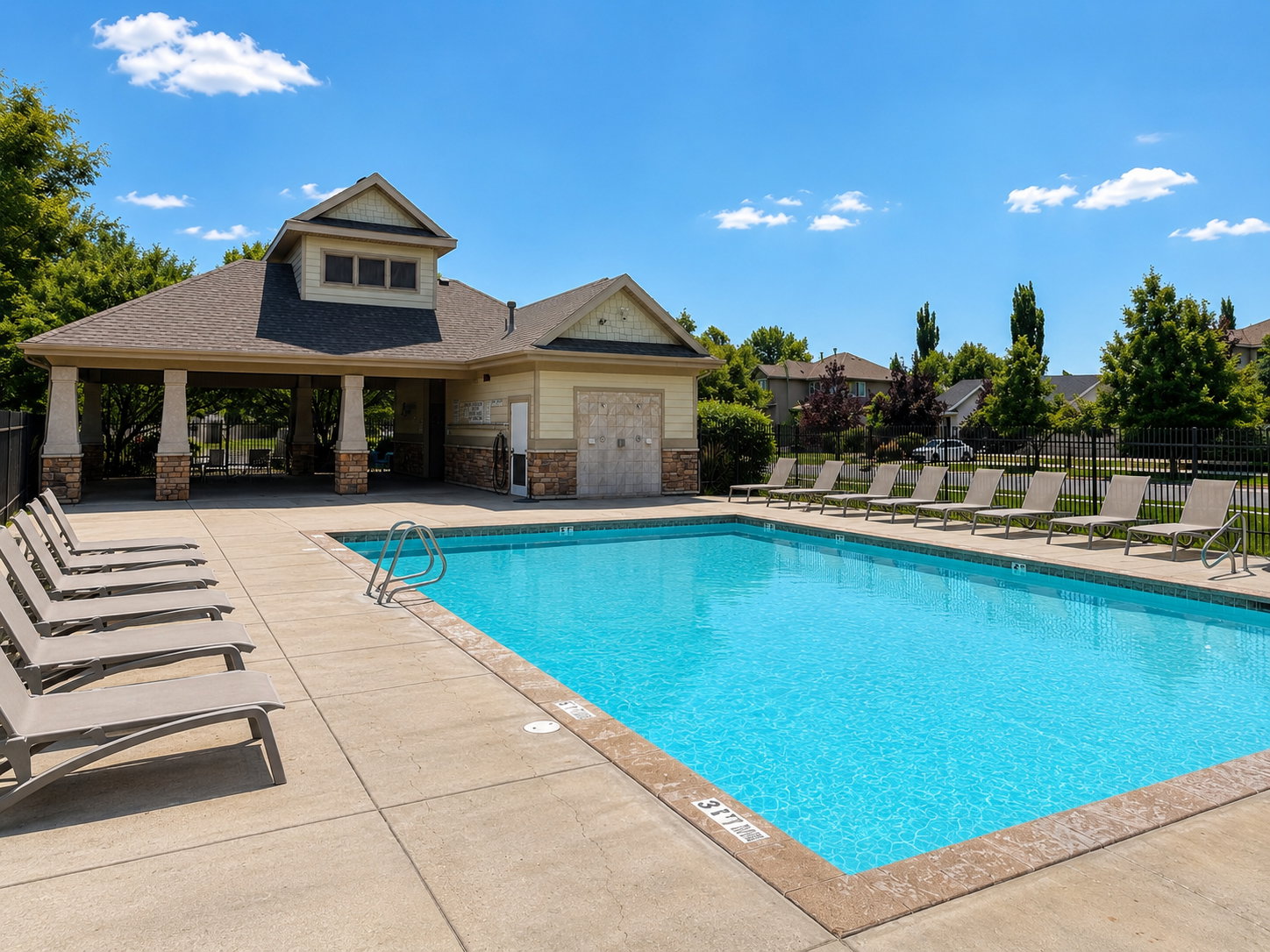 Outdoor swimming pool with concrete decking and perimeter fencing