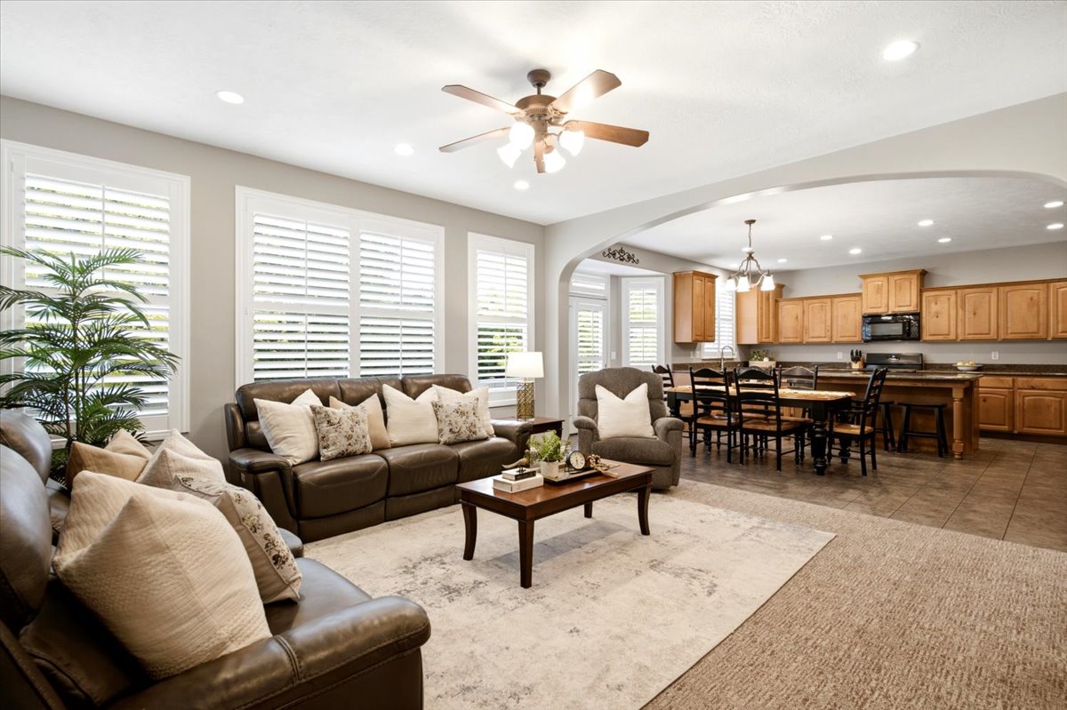 Open-concept living space featuring recessed lighting, a ceiling fan, and white plantation shutters