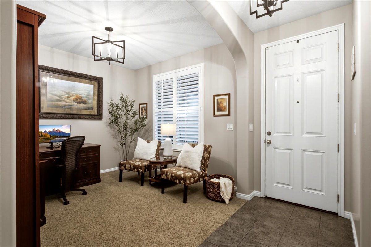 Entryway featuring a paneled door, archway, and tile flooring