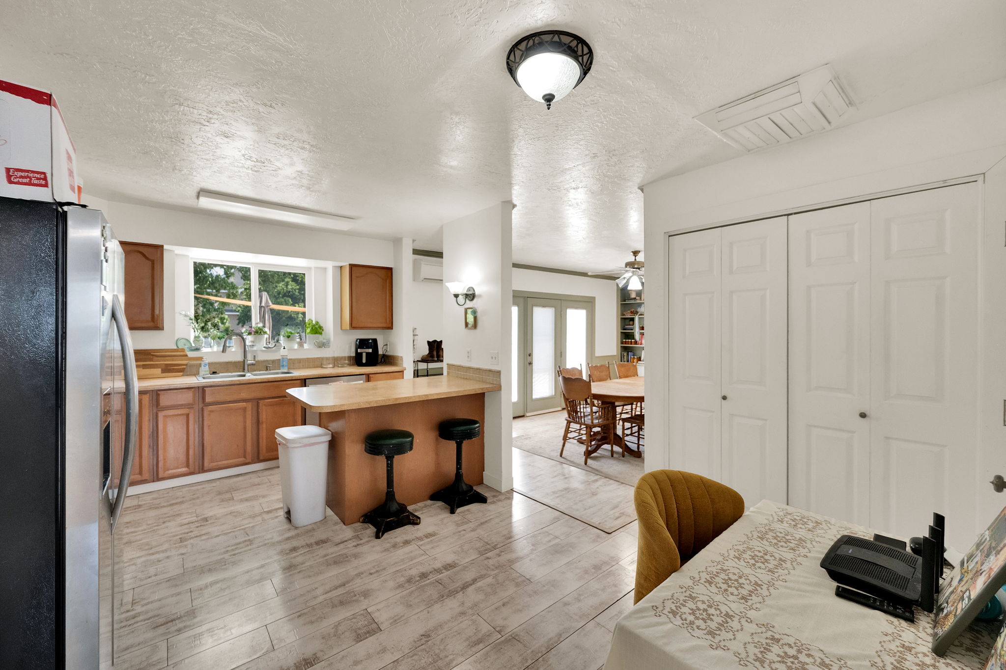 Kitchen featuring wood-finish flooring, ample cabinetry, a double basin sink, and a breakfast bar