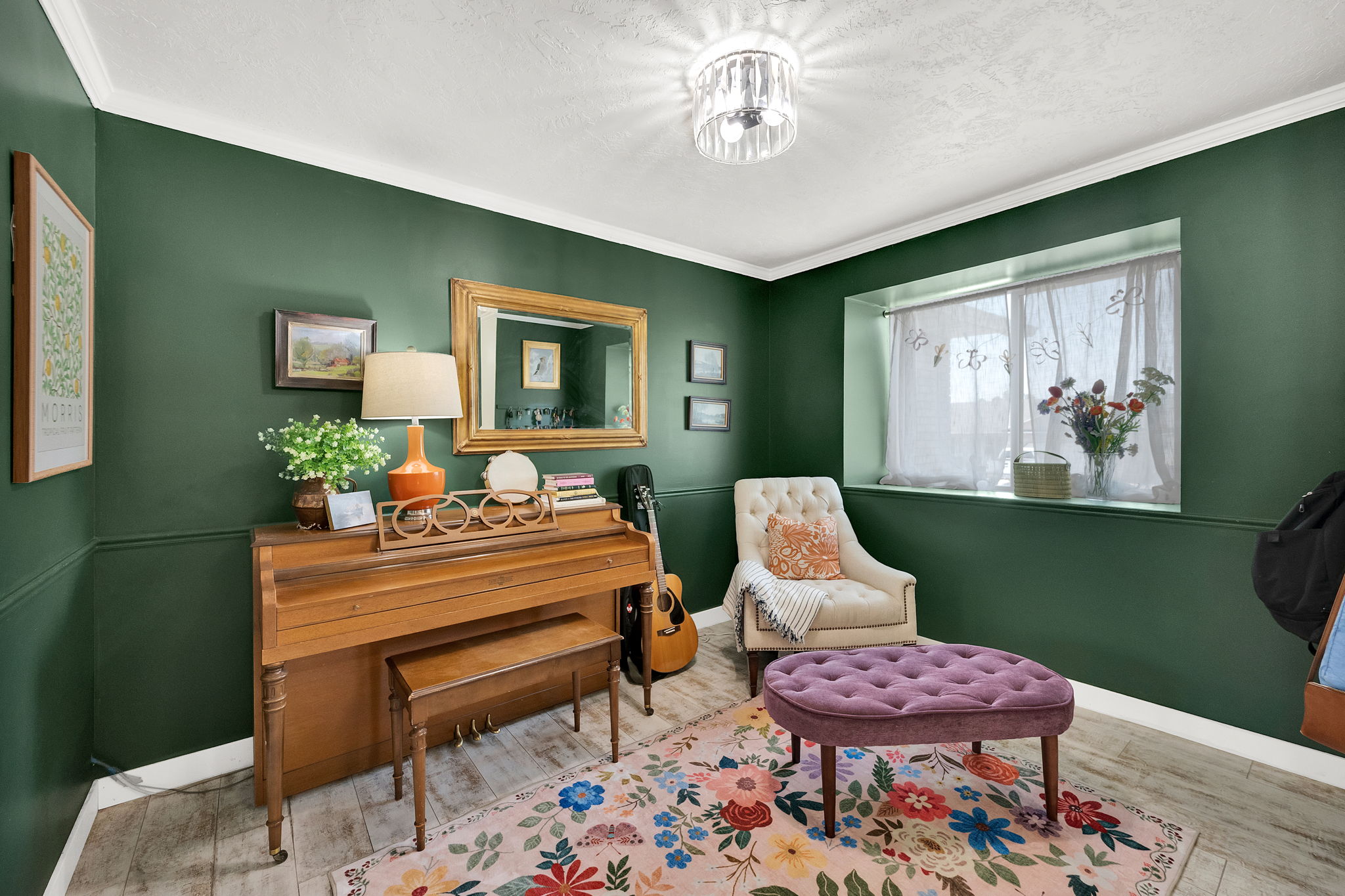 Room featuring wood-finish flooring and deep green walls with white crown molding