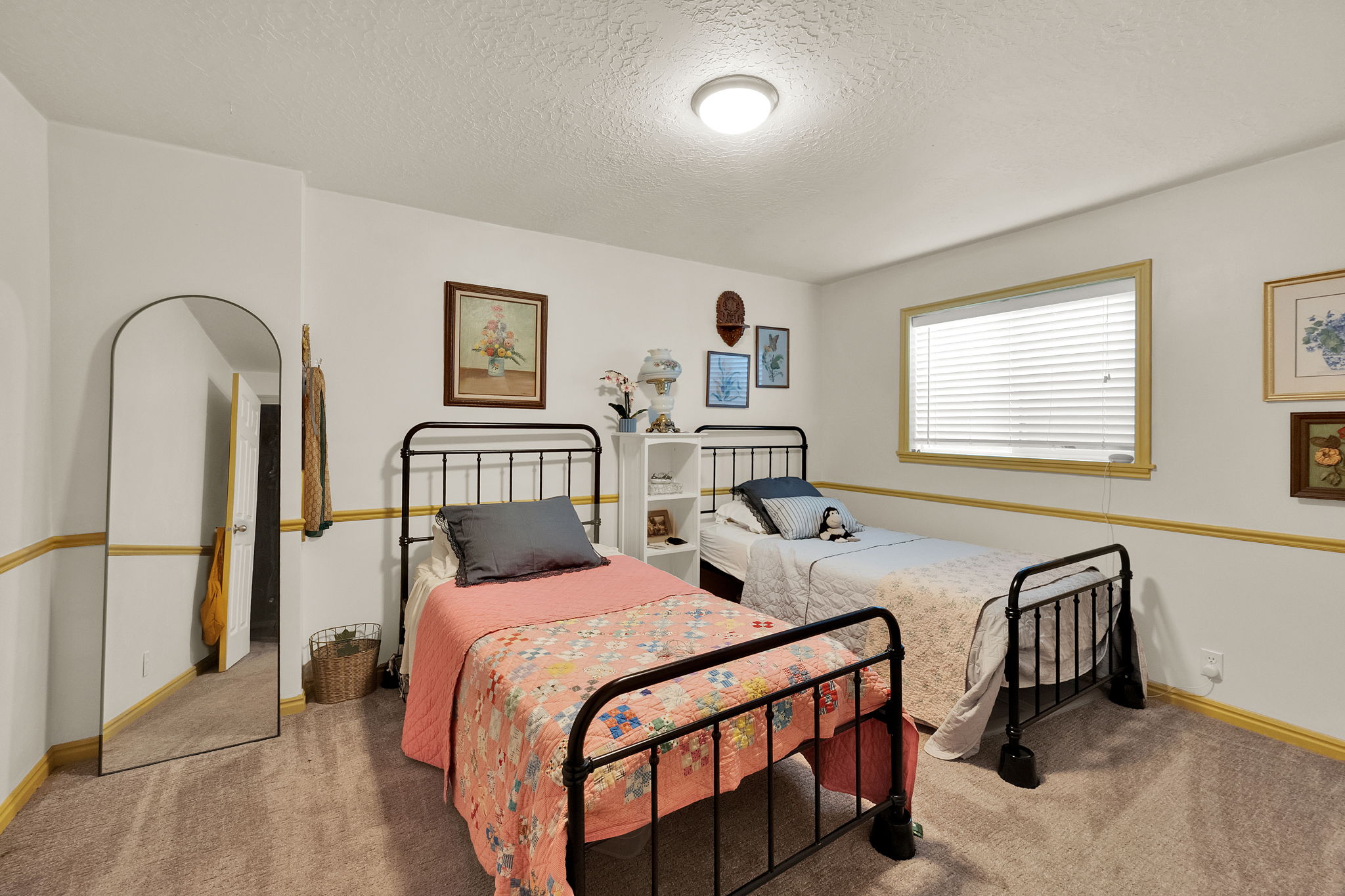 Carpeted room featuring a window with blinds, white walls, and a ceiling-mounted light fixture