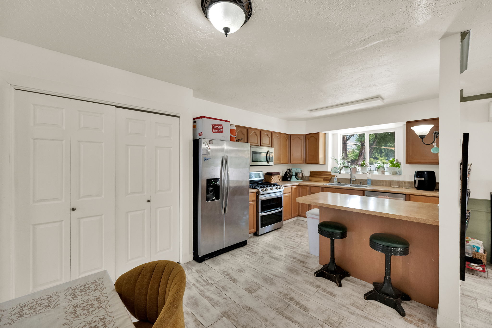 Kitchen featuring wood-finish flooring, natural wood cabinetry, and stainless steel appliances