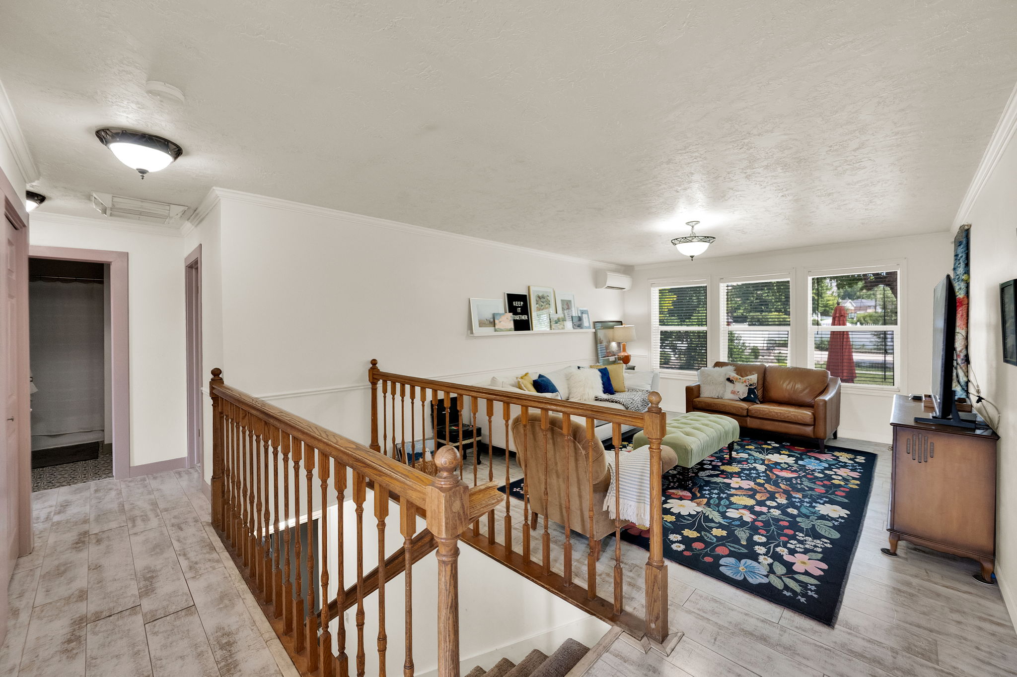 Living area with wood-finish flooring and multiple windows