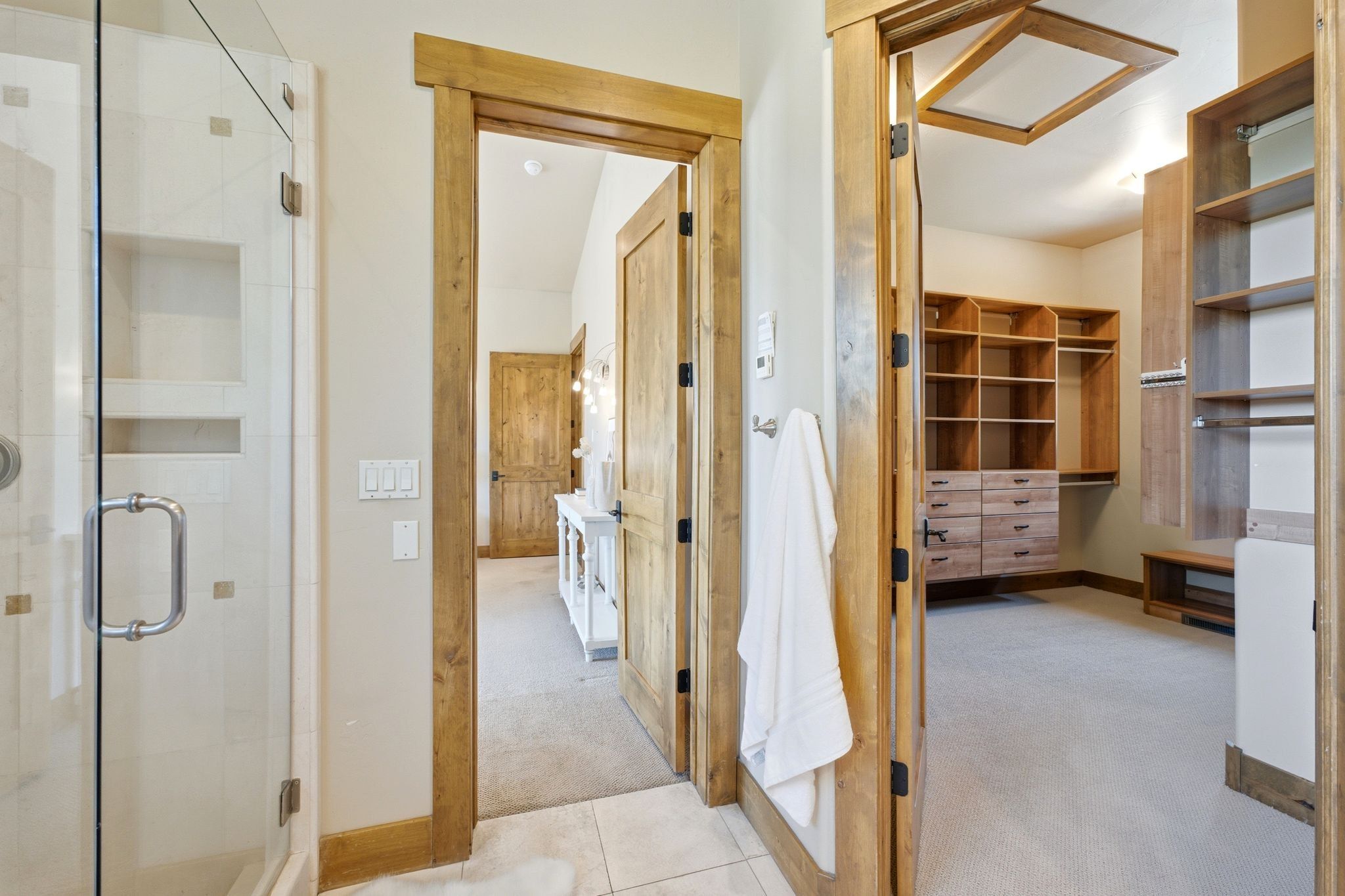 Walk-in shower with clear glass enclosure and tiled interior featuring built-in niches