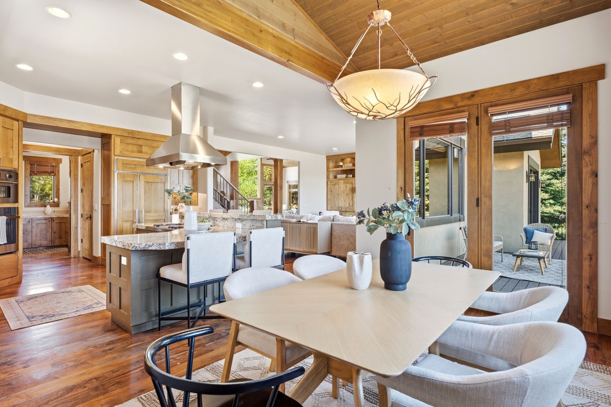 Spacious kitchen and dining area featuring wood-finish flooring, a vaulted wood-paneled ceiling, and recessed lighting