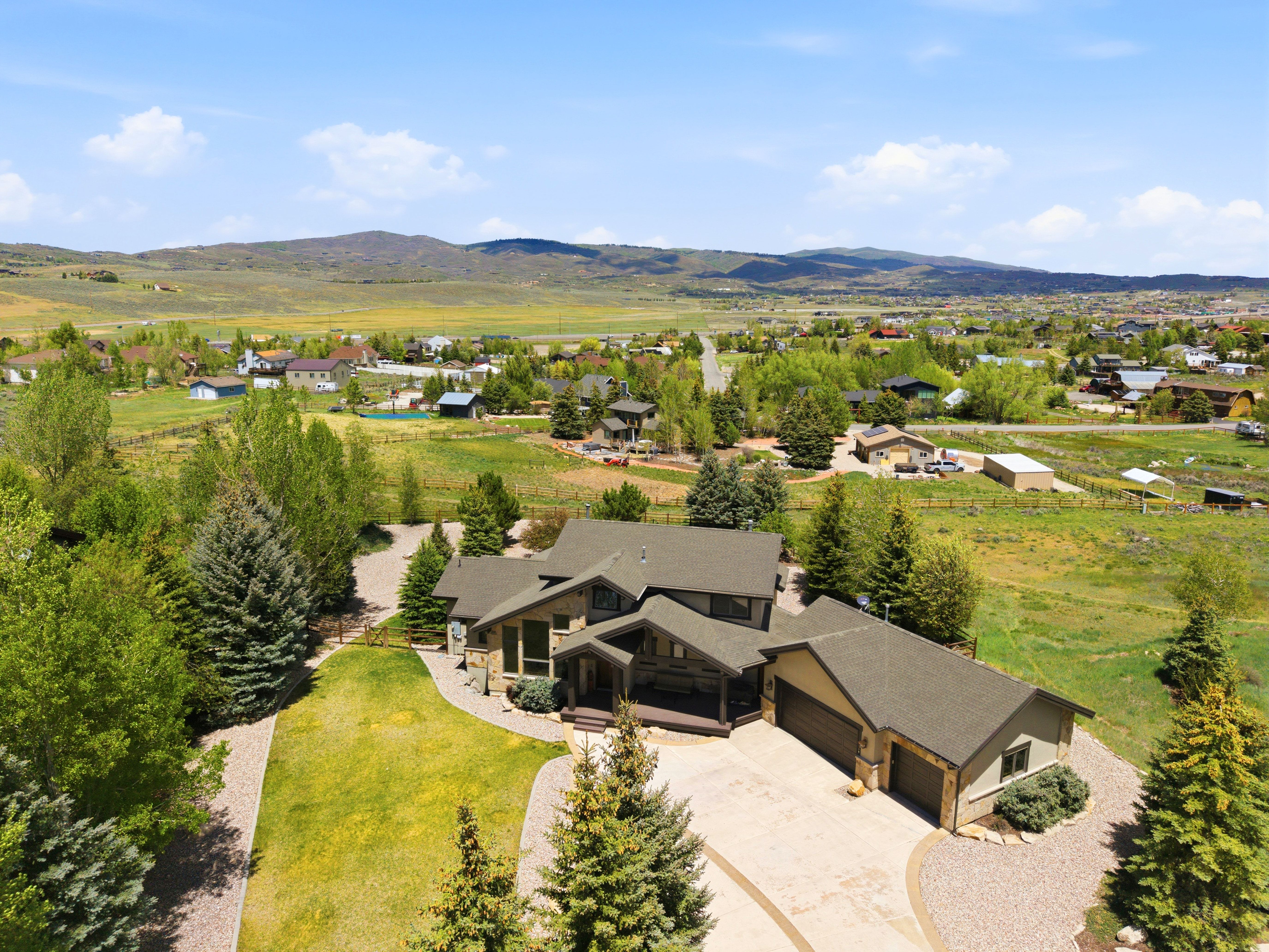 Expansive property featuring a stone and stucco exterior, multiple rooflines, and an attached two-car garage
