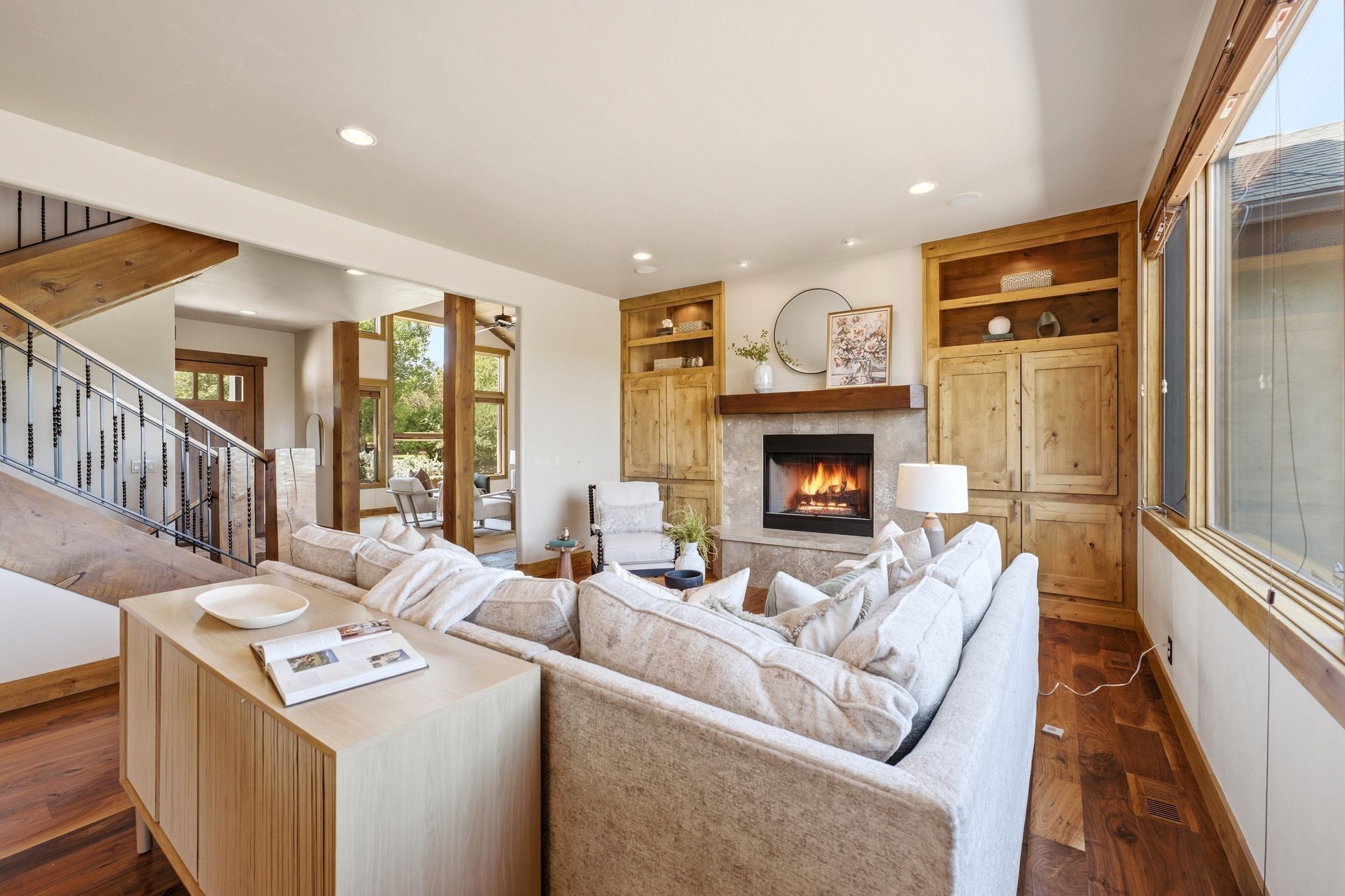 Living area featuring a gas fireplace with a stone surround, wood mantel, and built-in wood cabinetry