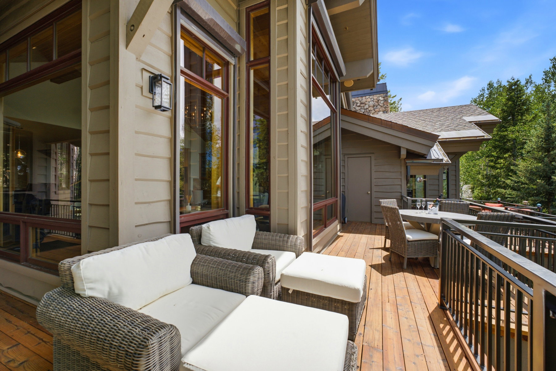 Expansive wood-finish deck with metal railings, offering ample space for outdoor seating