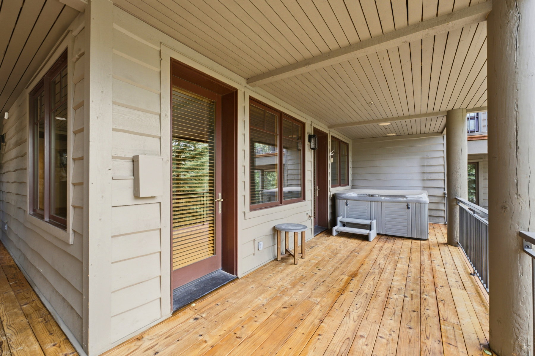 Spacious outdoor deck featuring natural wood flooring and a built-in hot tub