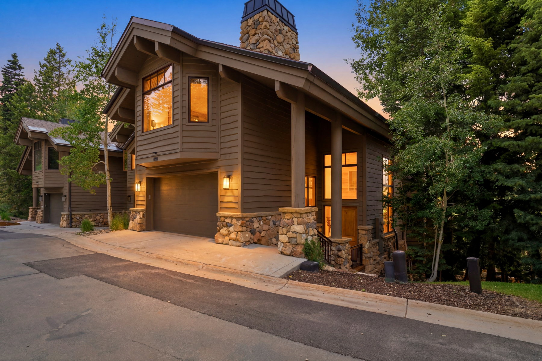 Contemporary multi-level exterior with rich wood siding and natural stone accents