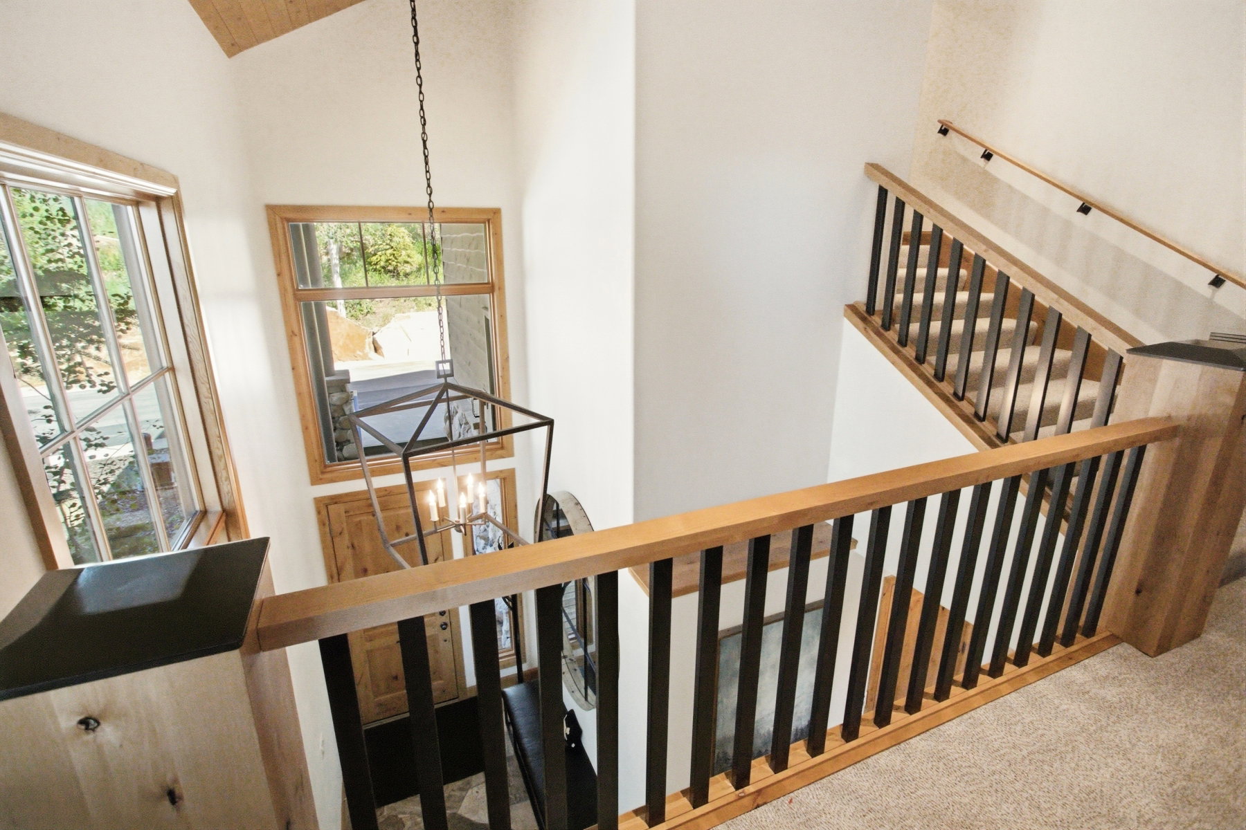 Foyer entry featuring a vaulted ceiling with wood-finish planks and a black metal chandelier