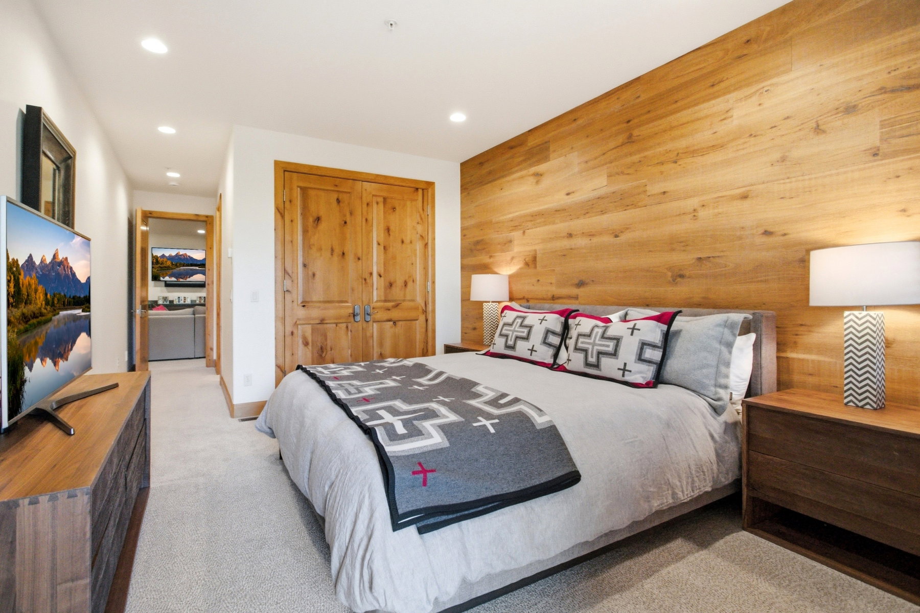 Bedroom featuring a wood-panel accent wall and recessed lighting