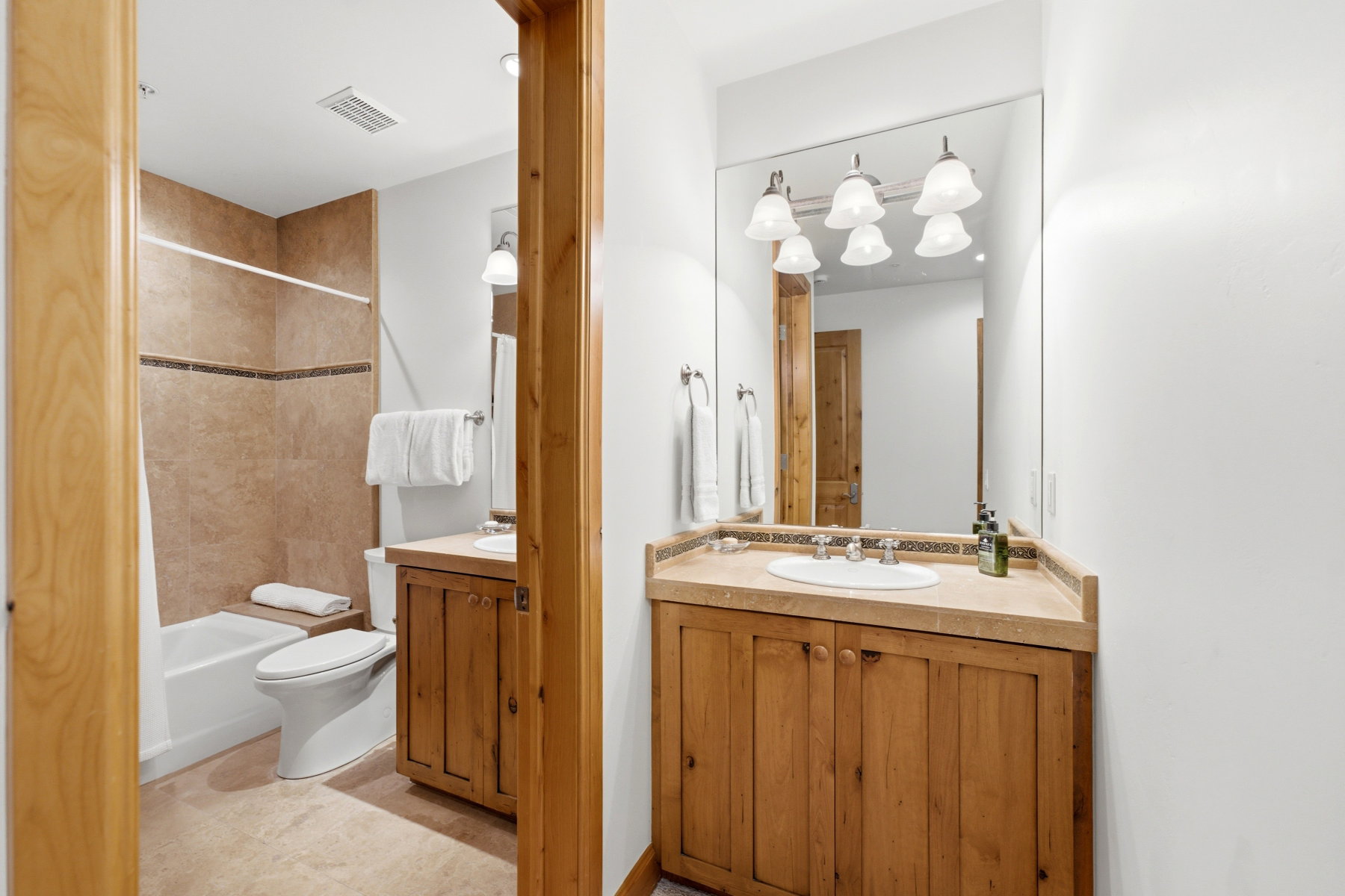 Bathroom featuring a full vanity with wood cabinetry, a light-toned countertop, and an integrated sink with chrome fixtures