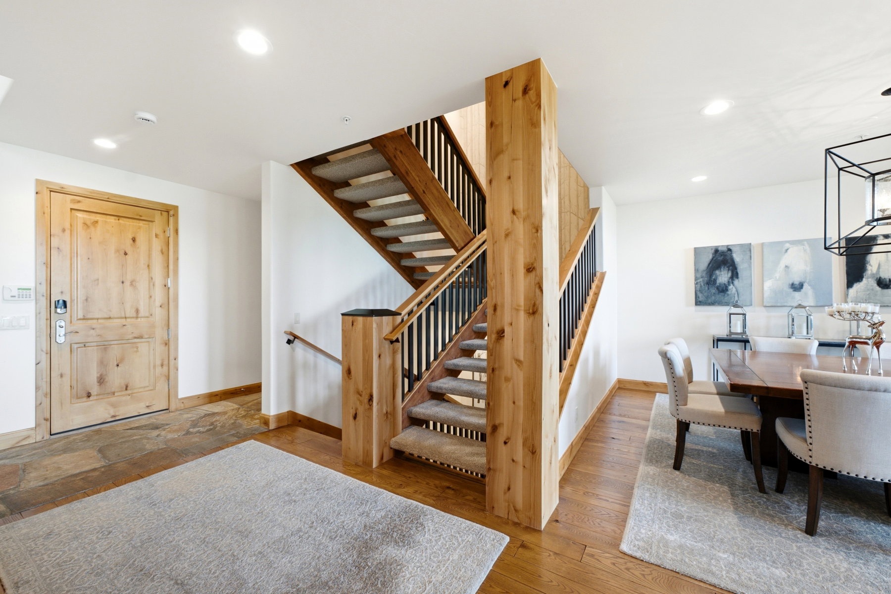 Foyer featuring a natural wood entry door, stone-finish flooring, and recessed lighting