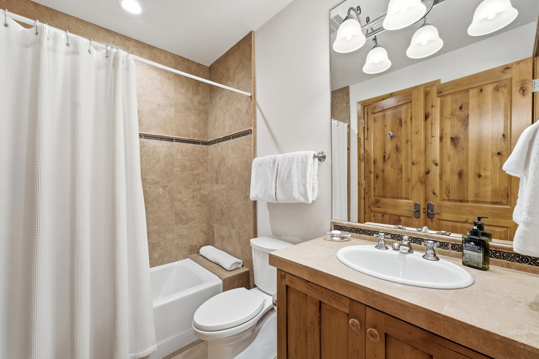 Full bathroom featuring a single vanity with wood cabinetry, a light-toned countertop, and an undermount sink