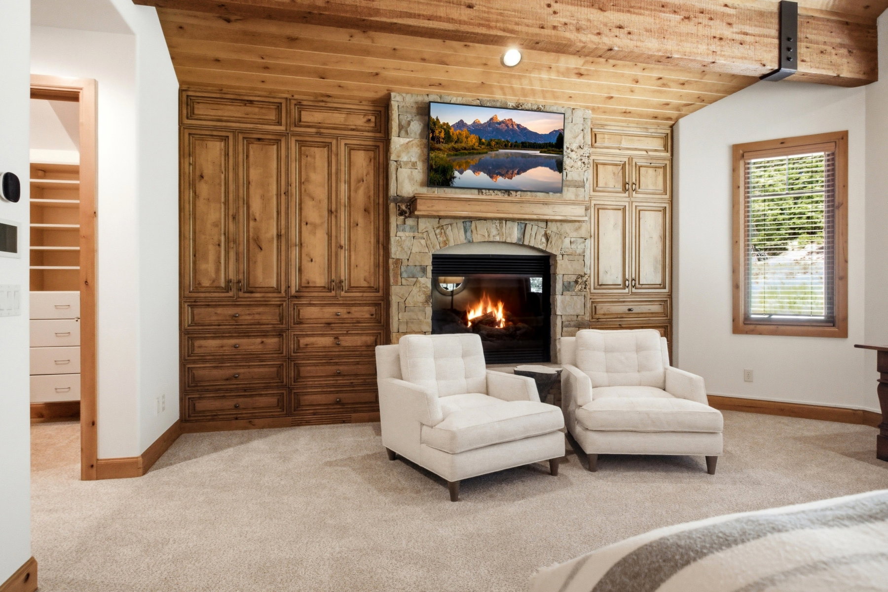 Stone-clad fireplace with a natural wood mantel