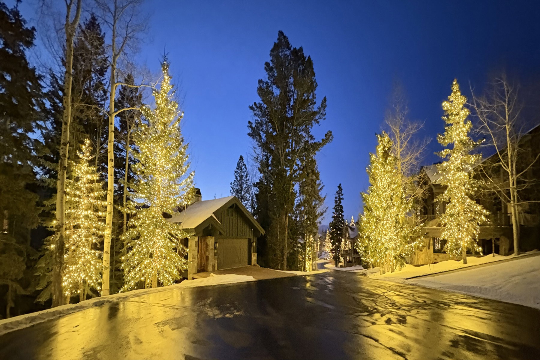 Wood-sided garage with stone accents beneath a gabled roofline