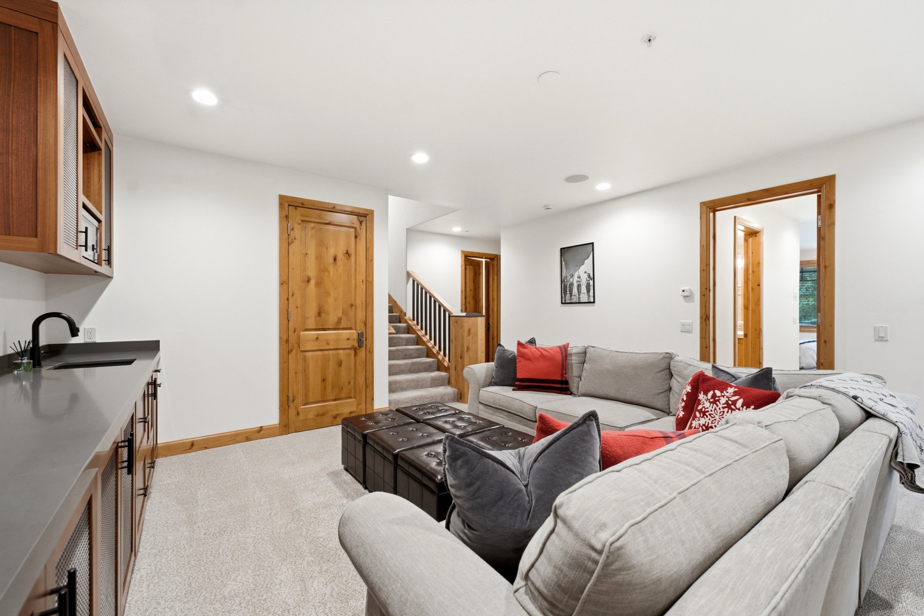 Lower-level living area featuring a built-in wet bar with dark countertops and wood cabinetry