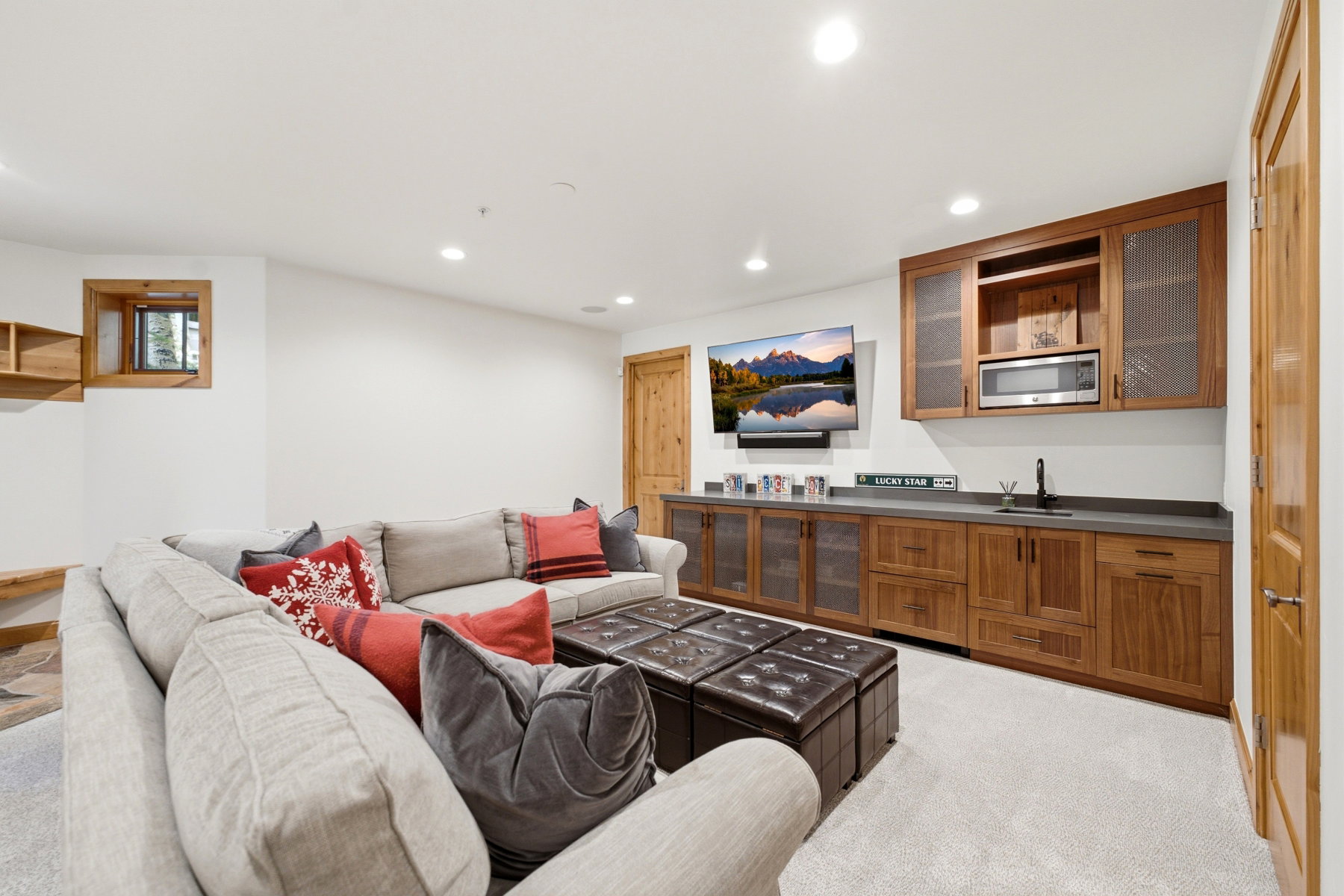 Recreation room featuring a built-in wet bar with wood cabinetry, integrated sink, and microwave