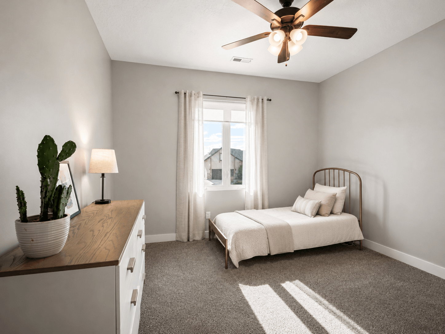 Carpeted room featuring a ceiling fan with integrated lighting, a window with curtains, and light gray wall paint