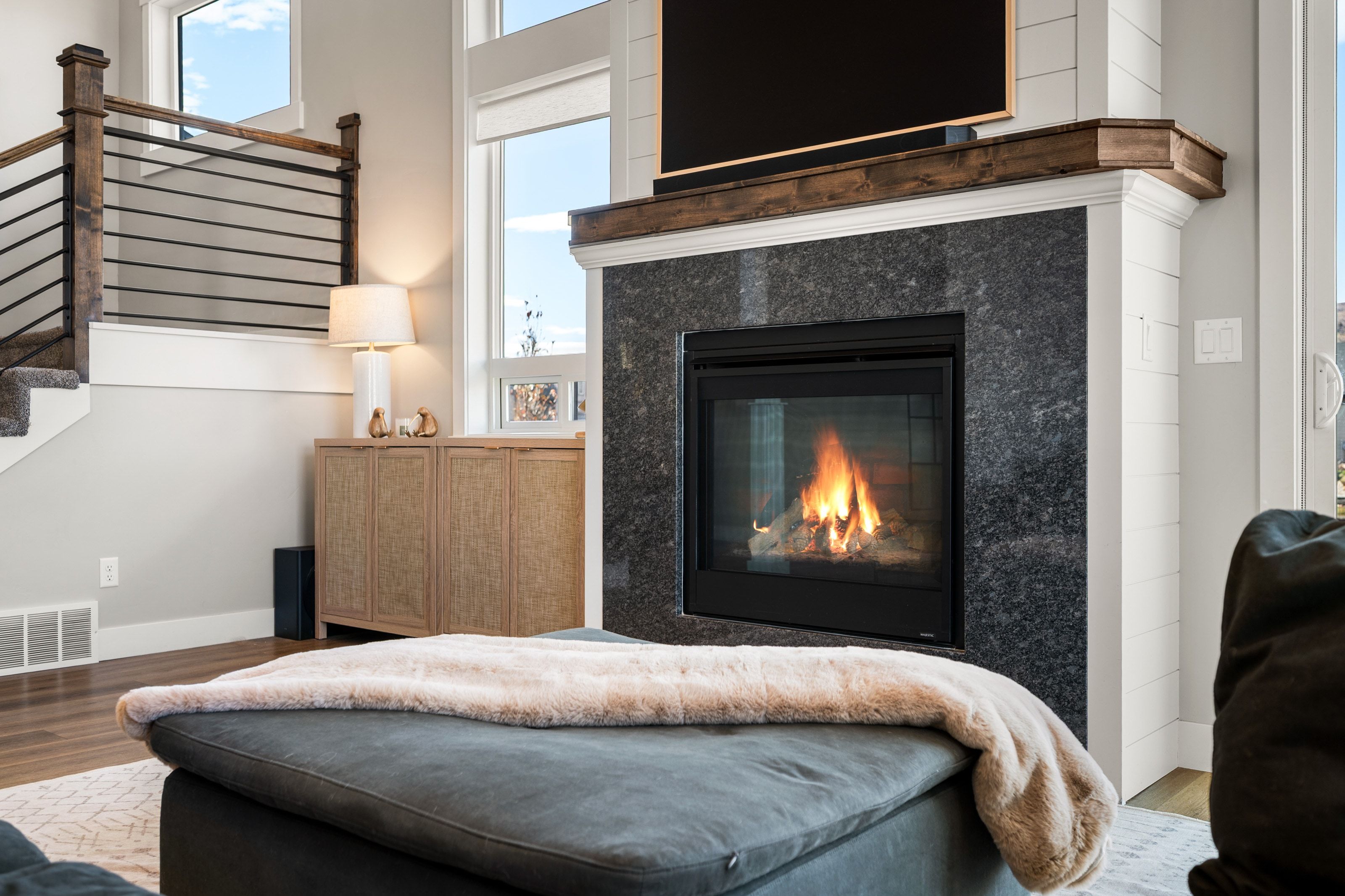 Fireplace with dark stone surround and wood mantel