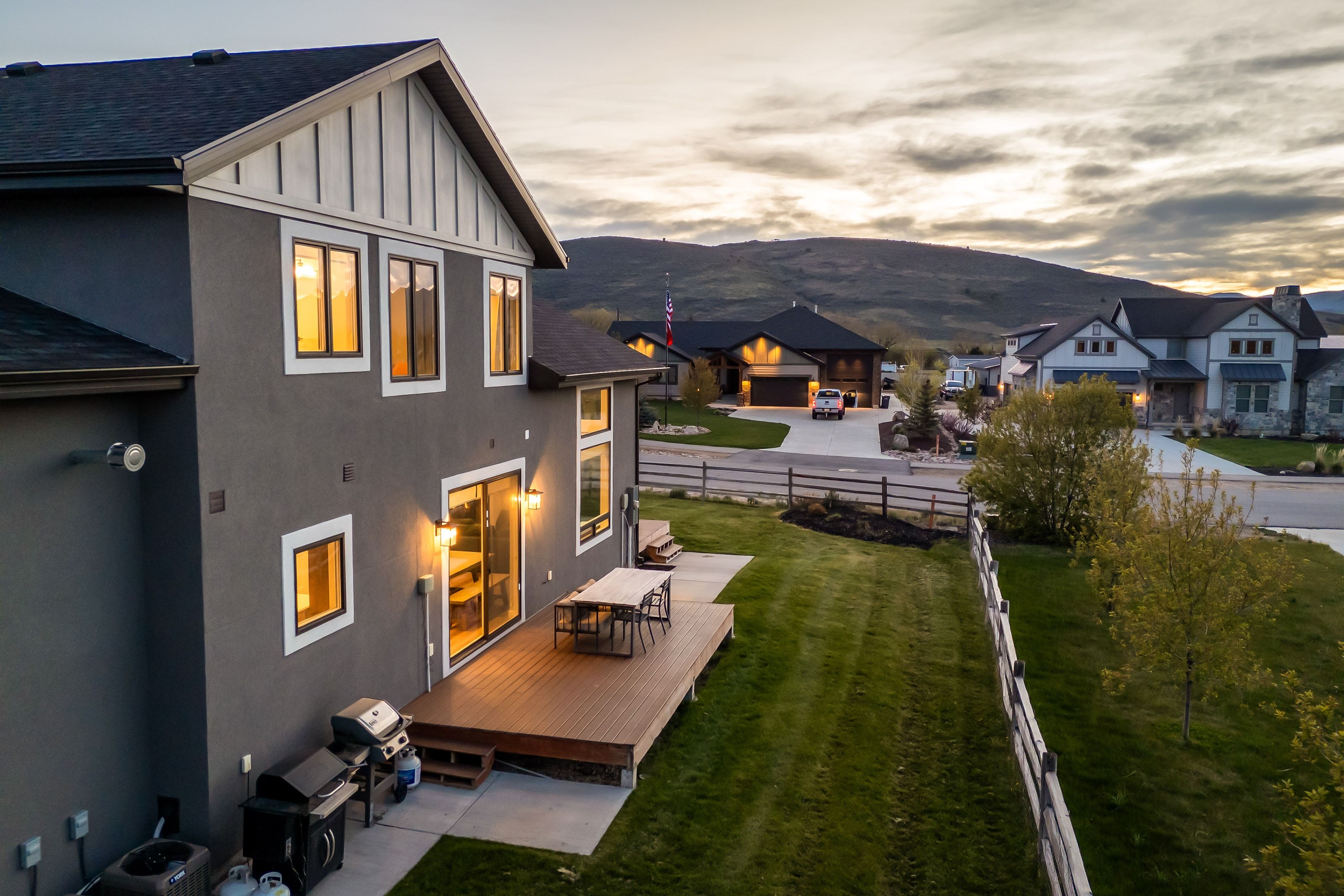 Expansive rear exterior featuring a dark gray stucco finish, white trim accents, and a contrasting dark roof