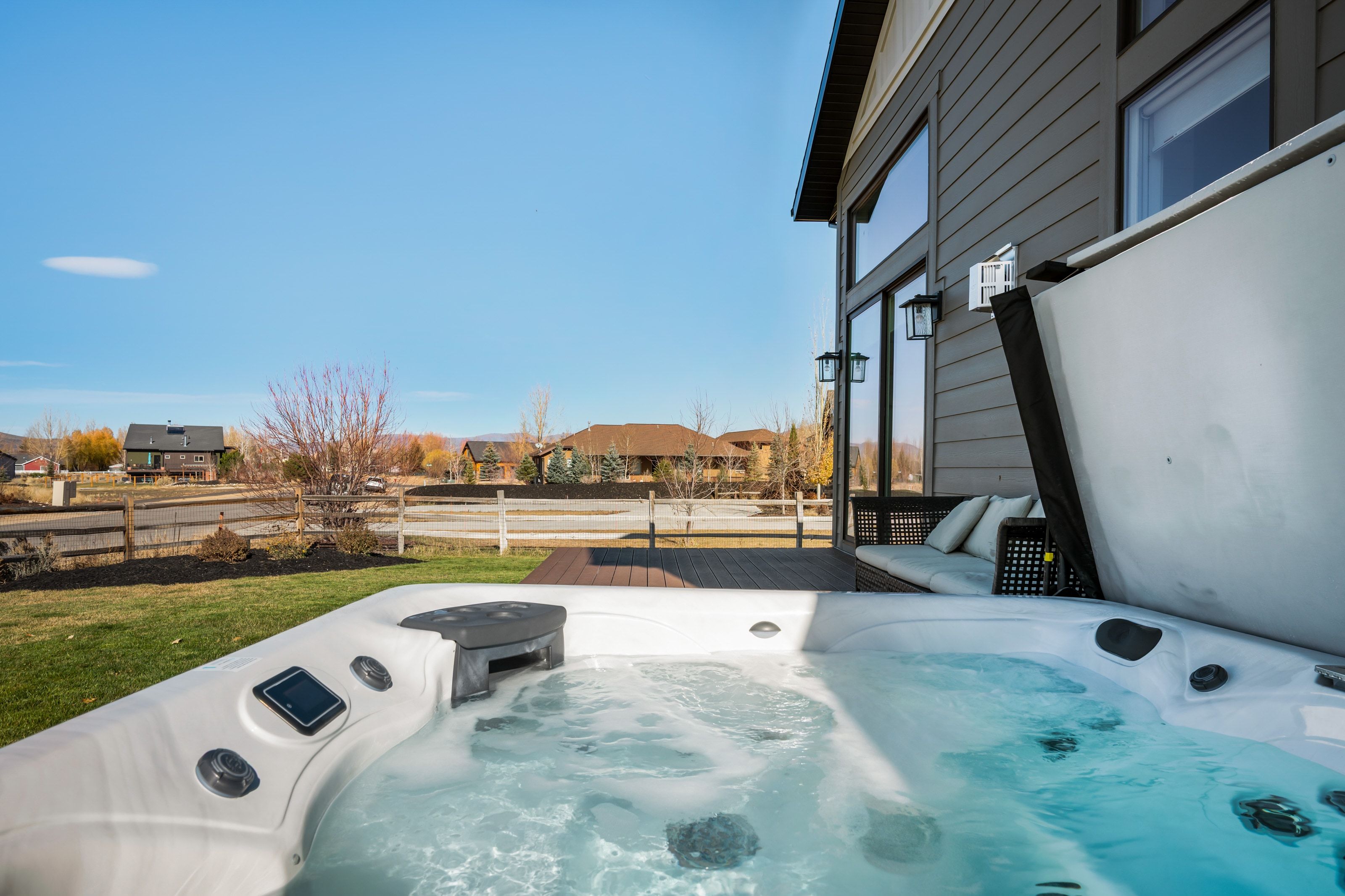 Outdoor hot tub with integrated controls situated on a wood-finish deck