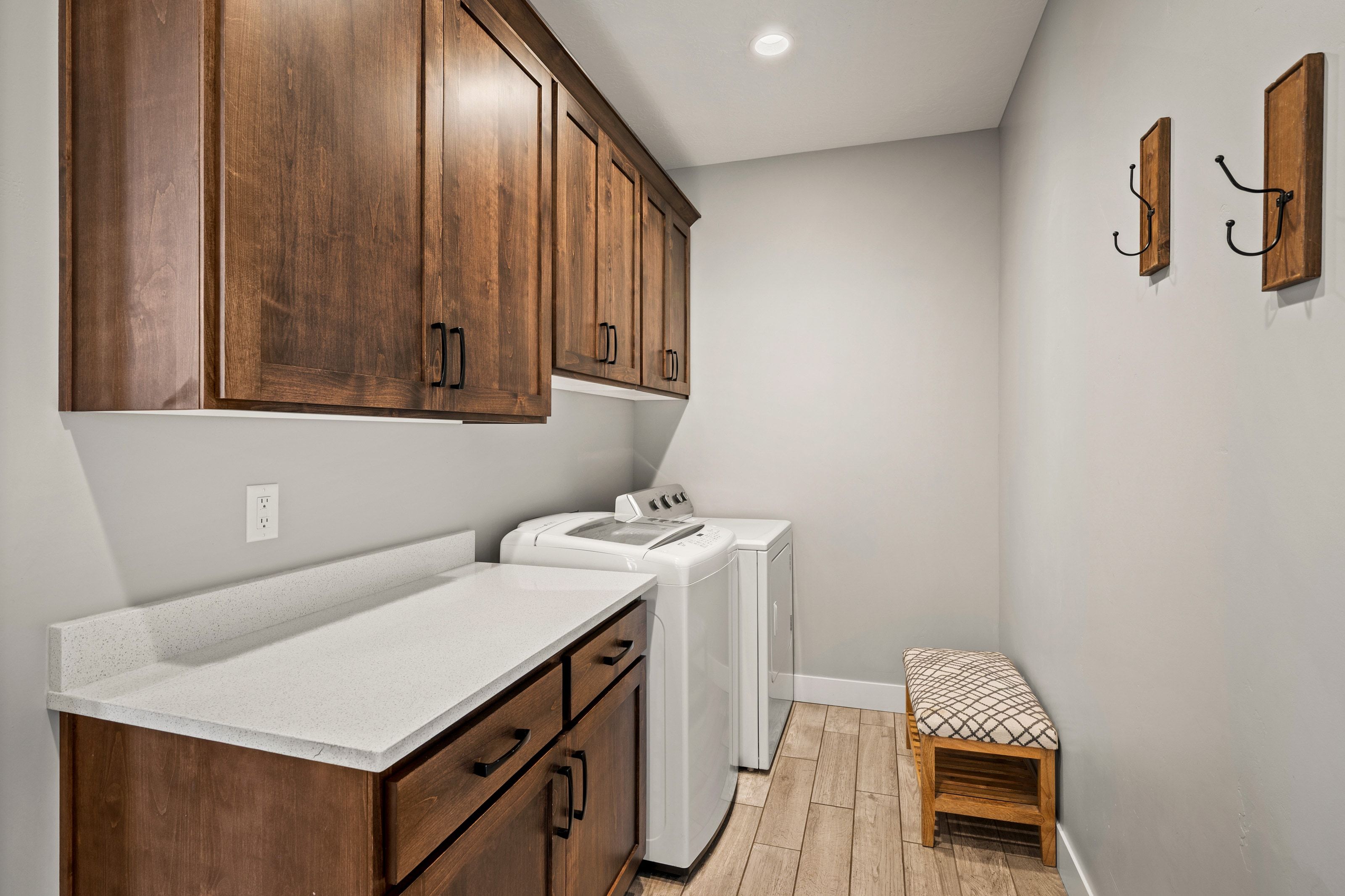 Dedicated laundry area featuring wood-finish flooring and light gray wall paint