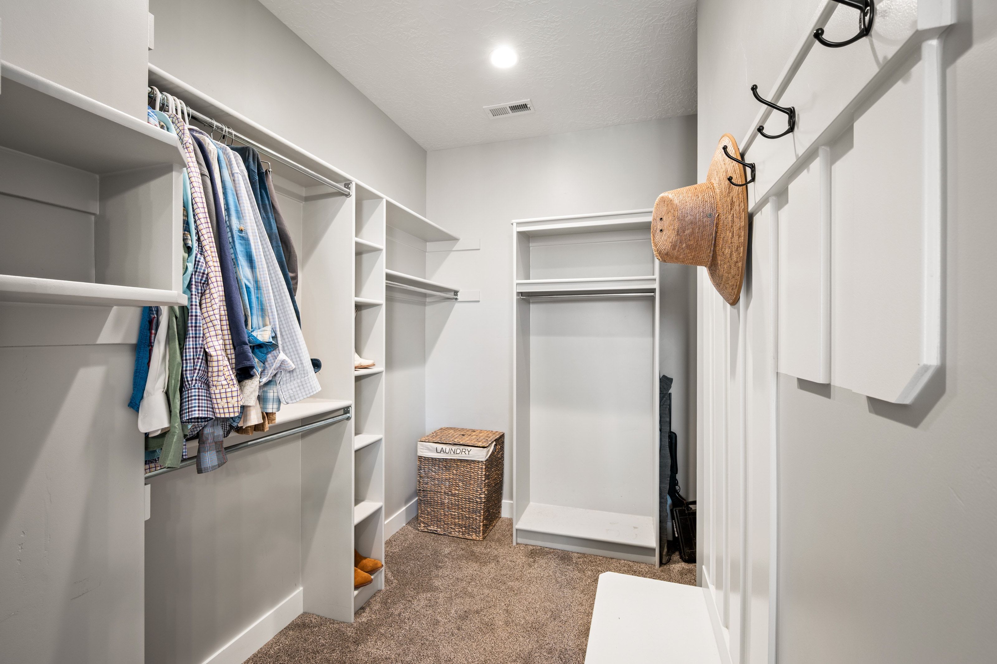 Walk-in closet featuring extensive built-in shelving, multiple hanging rods, recessed lighting, and soft carpet flooring
