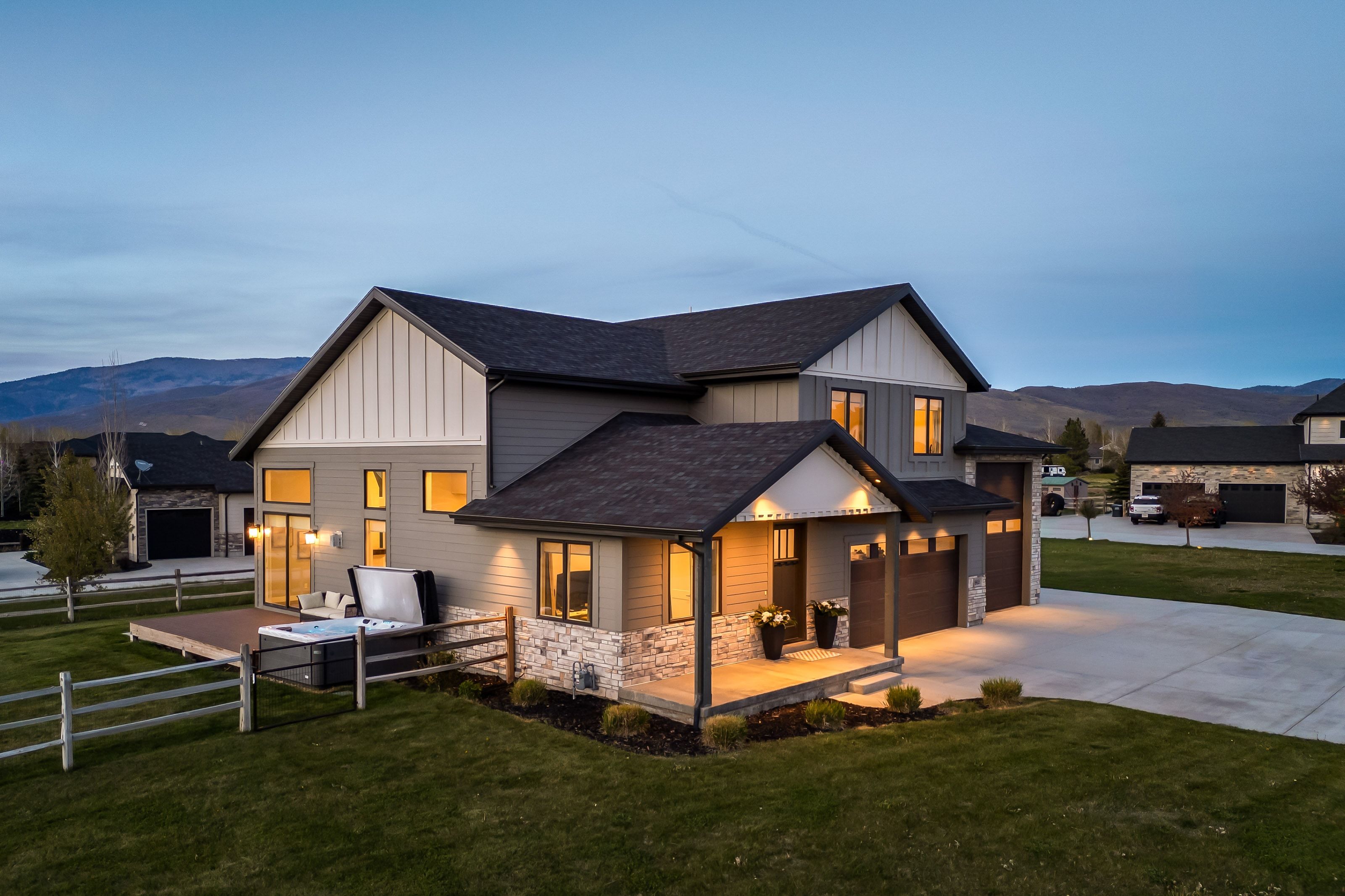 Modern two-story residence with a multi-textured facade featuring horizontal siding, vertical paneling, and stone accents