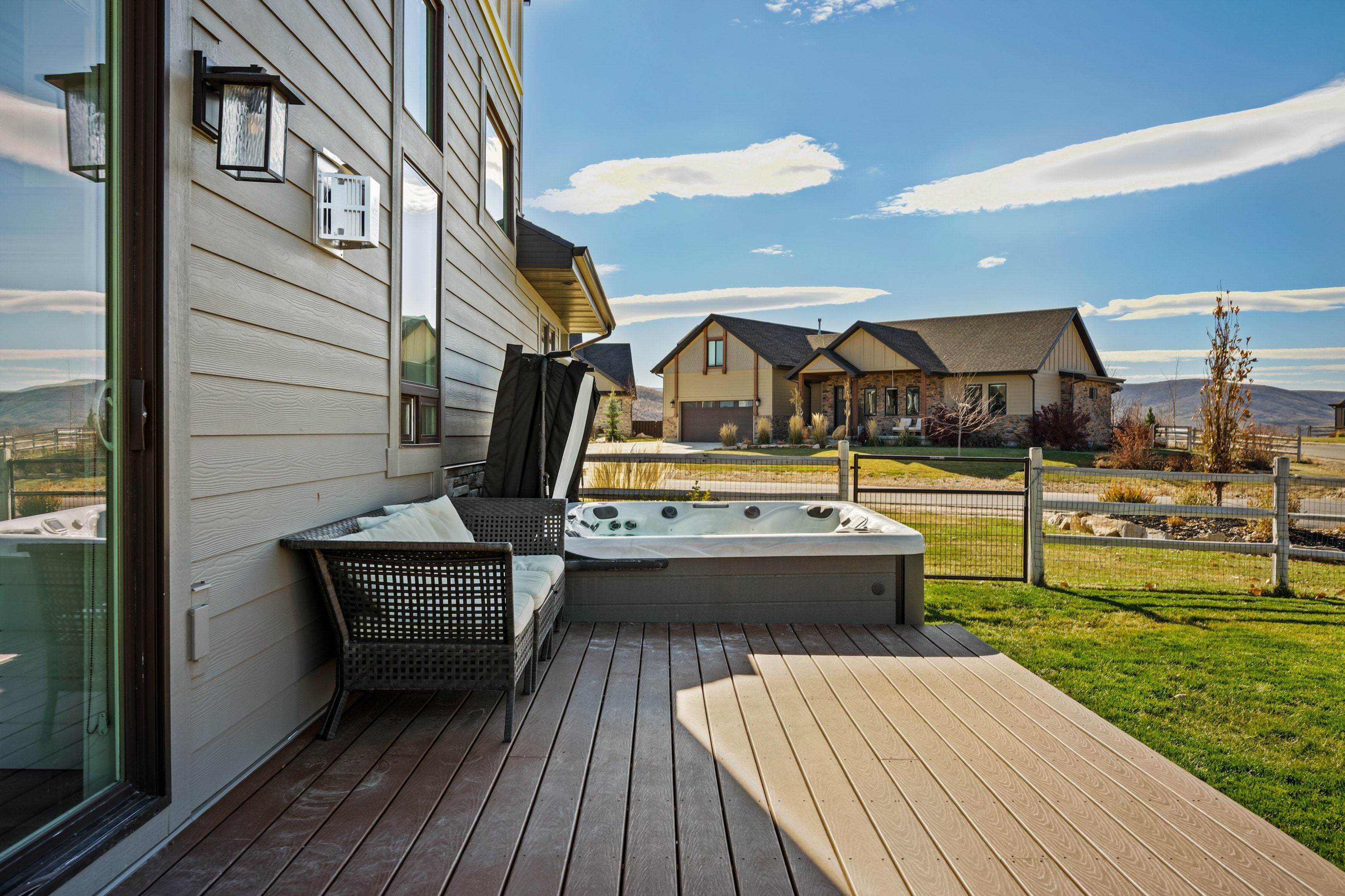 Expansive composite deck featuring an integrated hot tub and sliding glass door access
