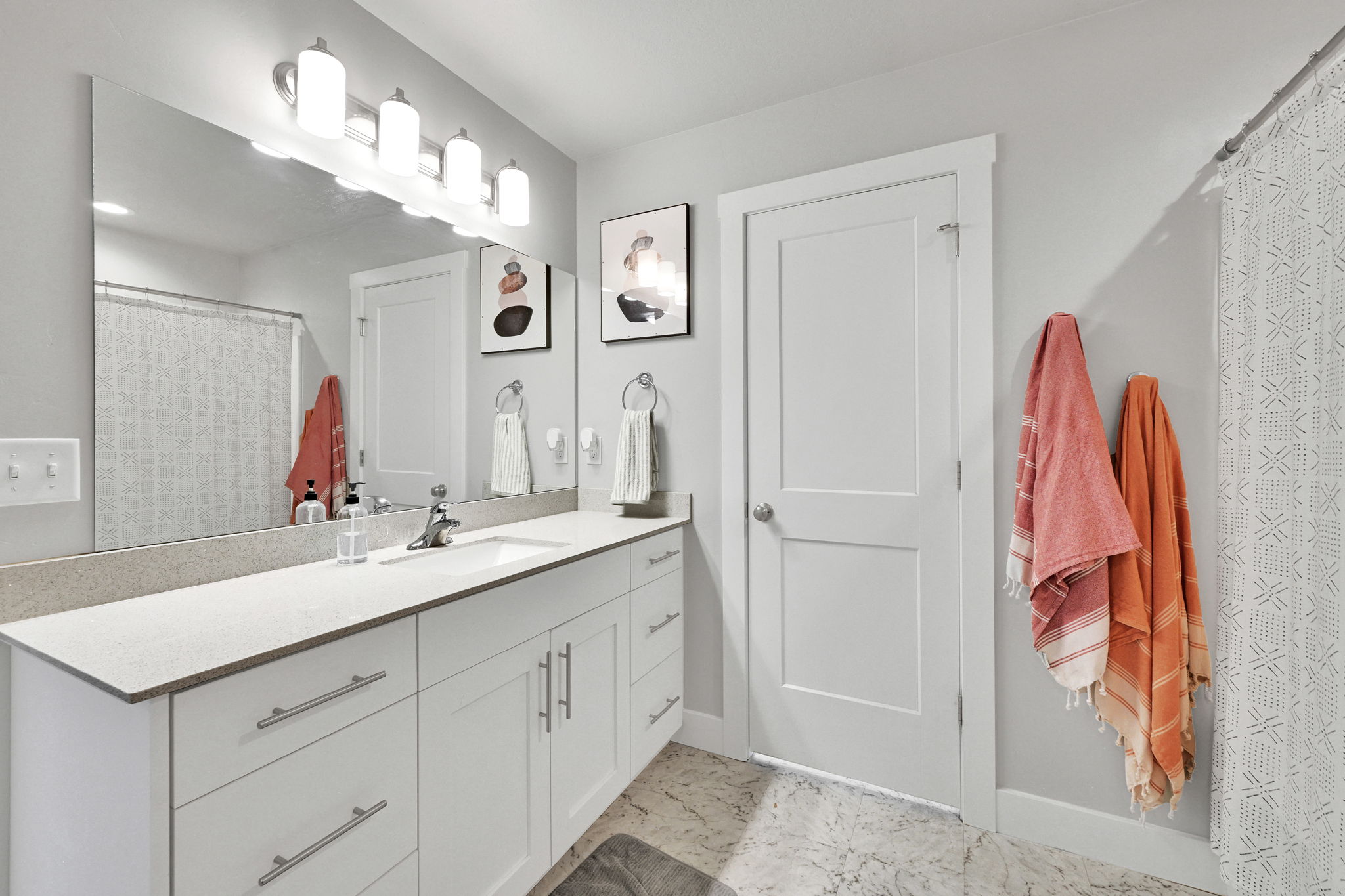 Spacious bathroom featuring an extended vanity with white cabinetry and a light-toned countertop
