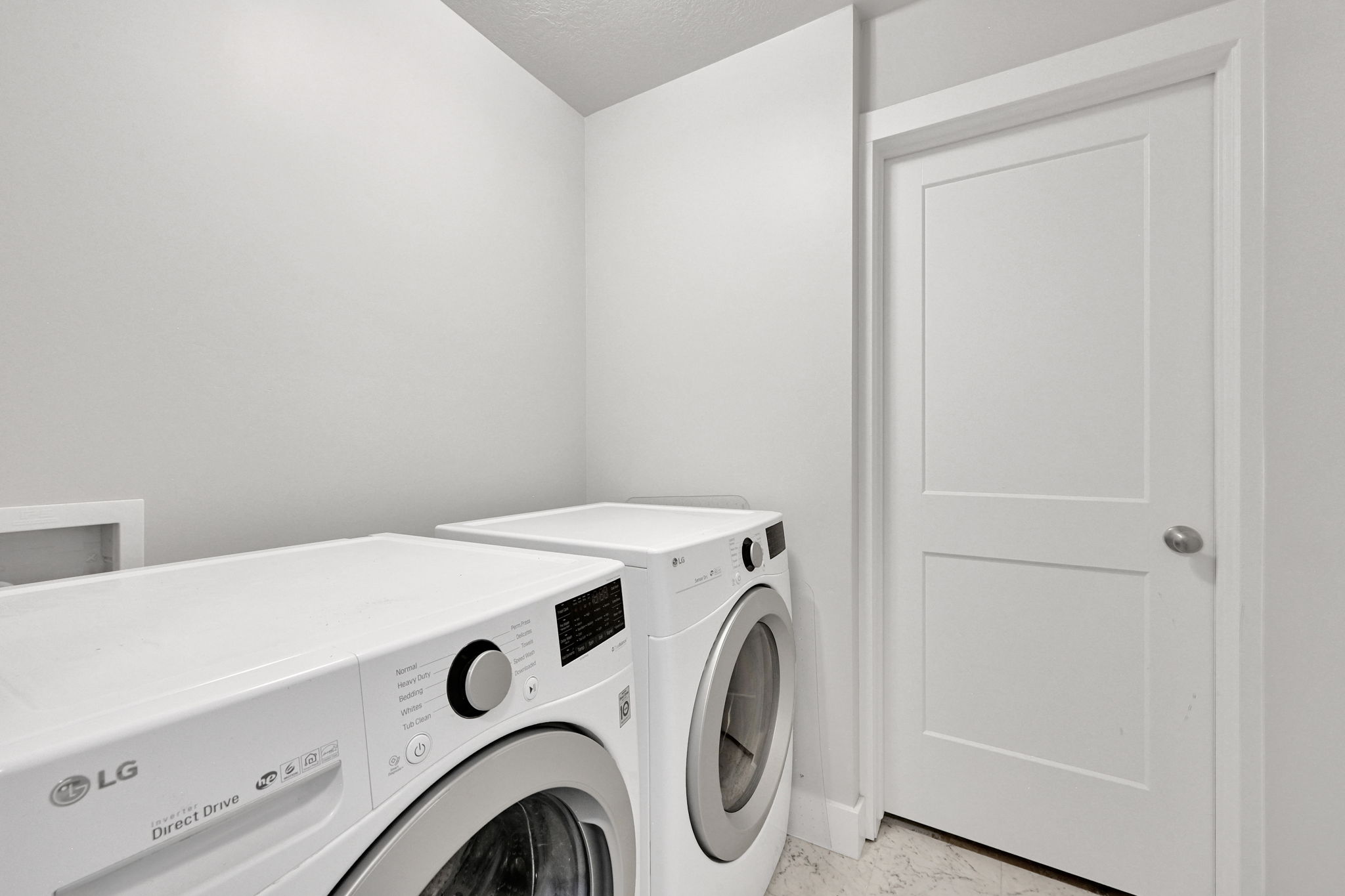 Dedicated laundry area featuring a front-loading washing machine and dryer