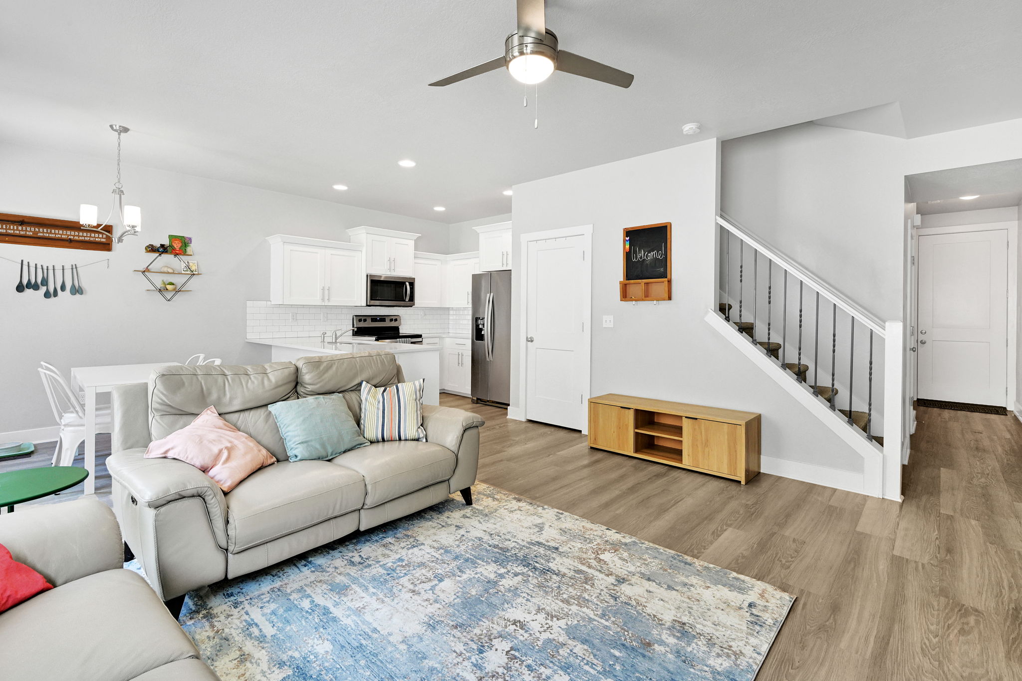 Open-concept living space featuring wood-finish flooring, a contemporary ceiling fan, and recessed lighting