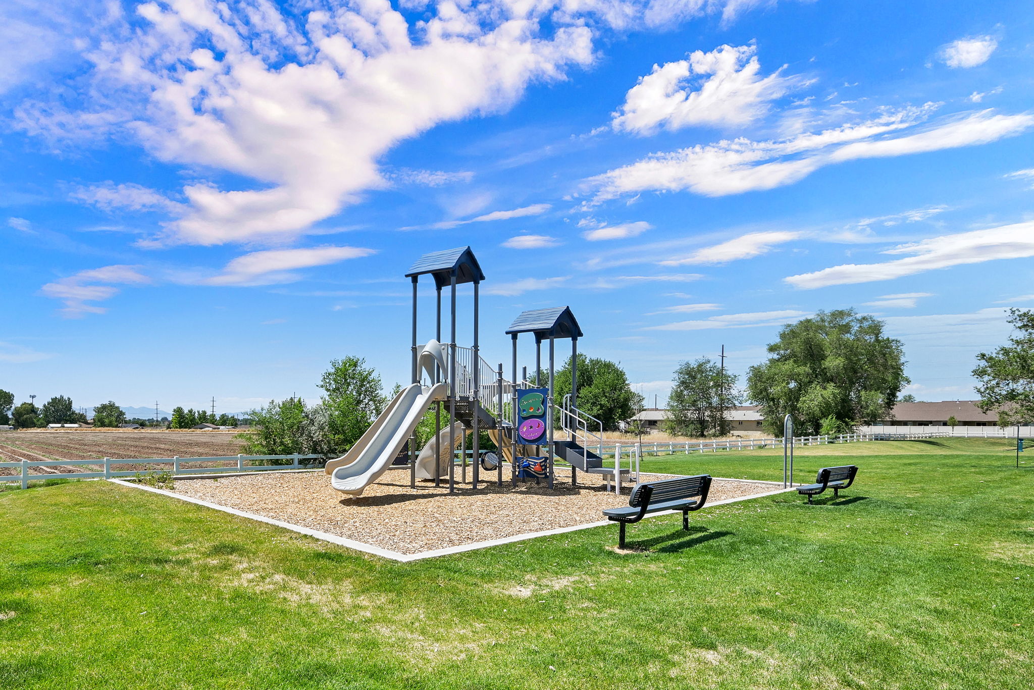 Outdoor playground featuring a slide, climbing elements, and protective ground covering